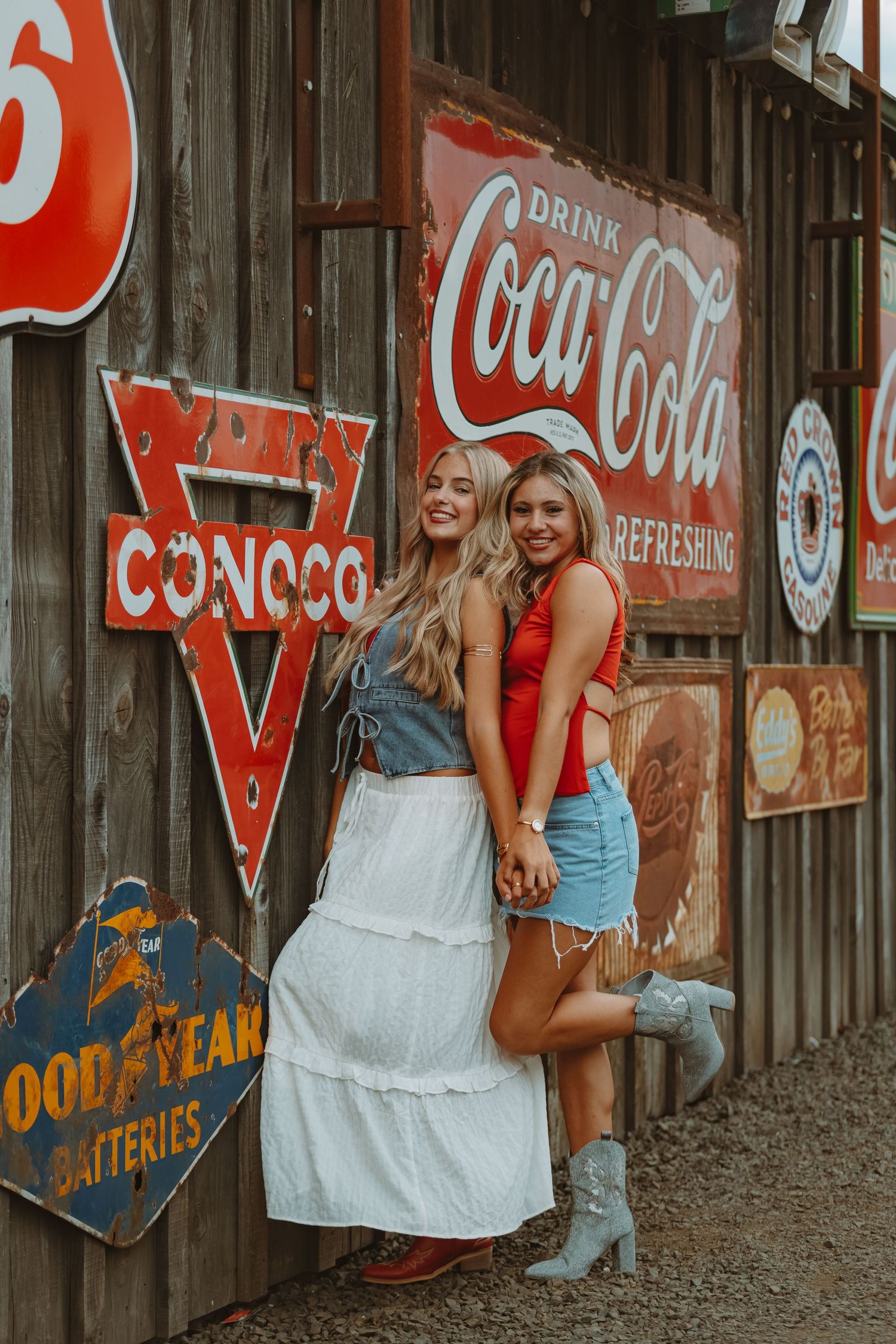 Vintage-themed photography with weathered Coca-Cola and Good Year signs on wooden wall.