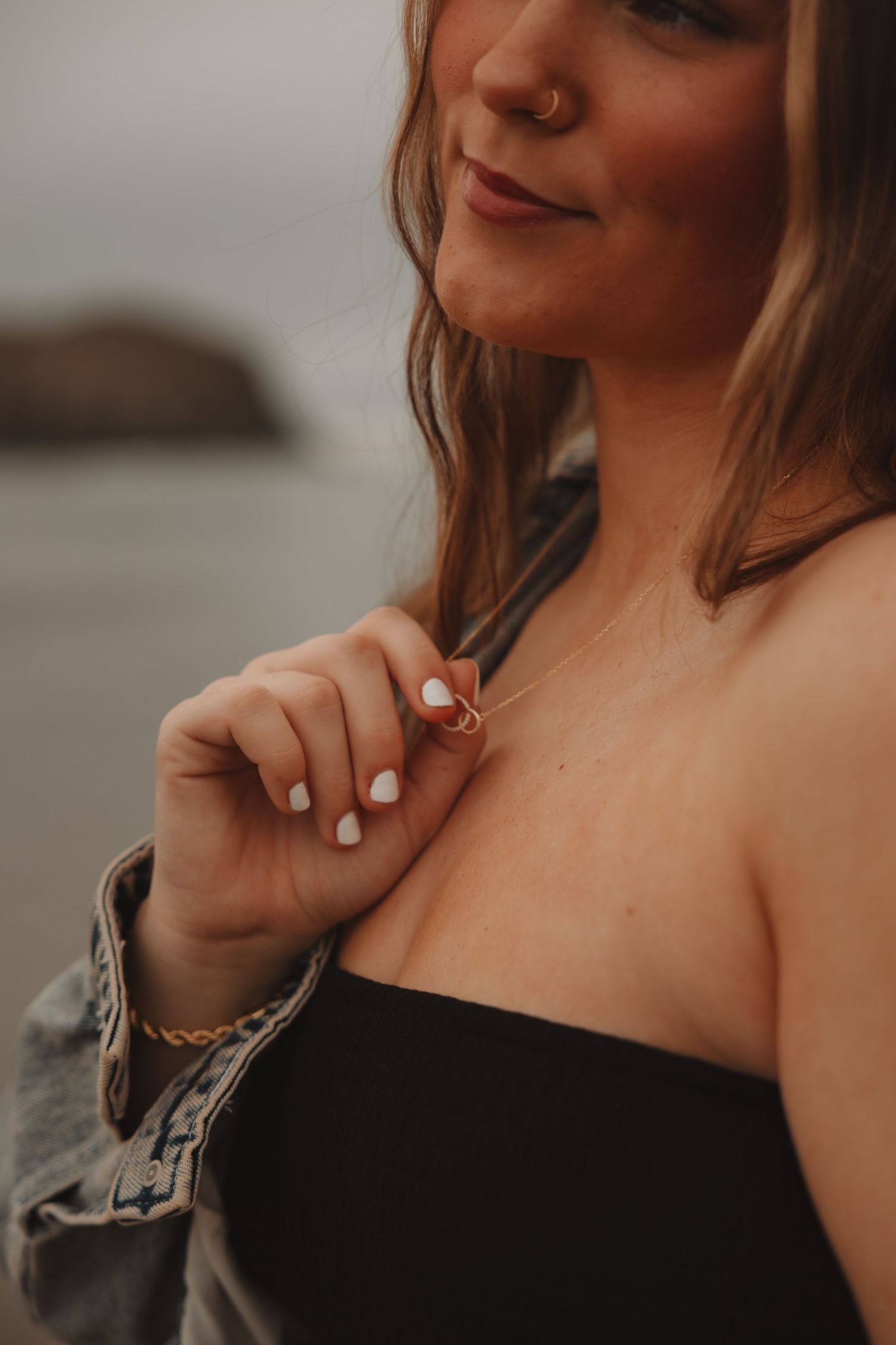 Artistic collage of cropped portraits showing shoulders and hands with white nail polish against a moody background.