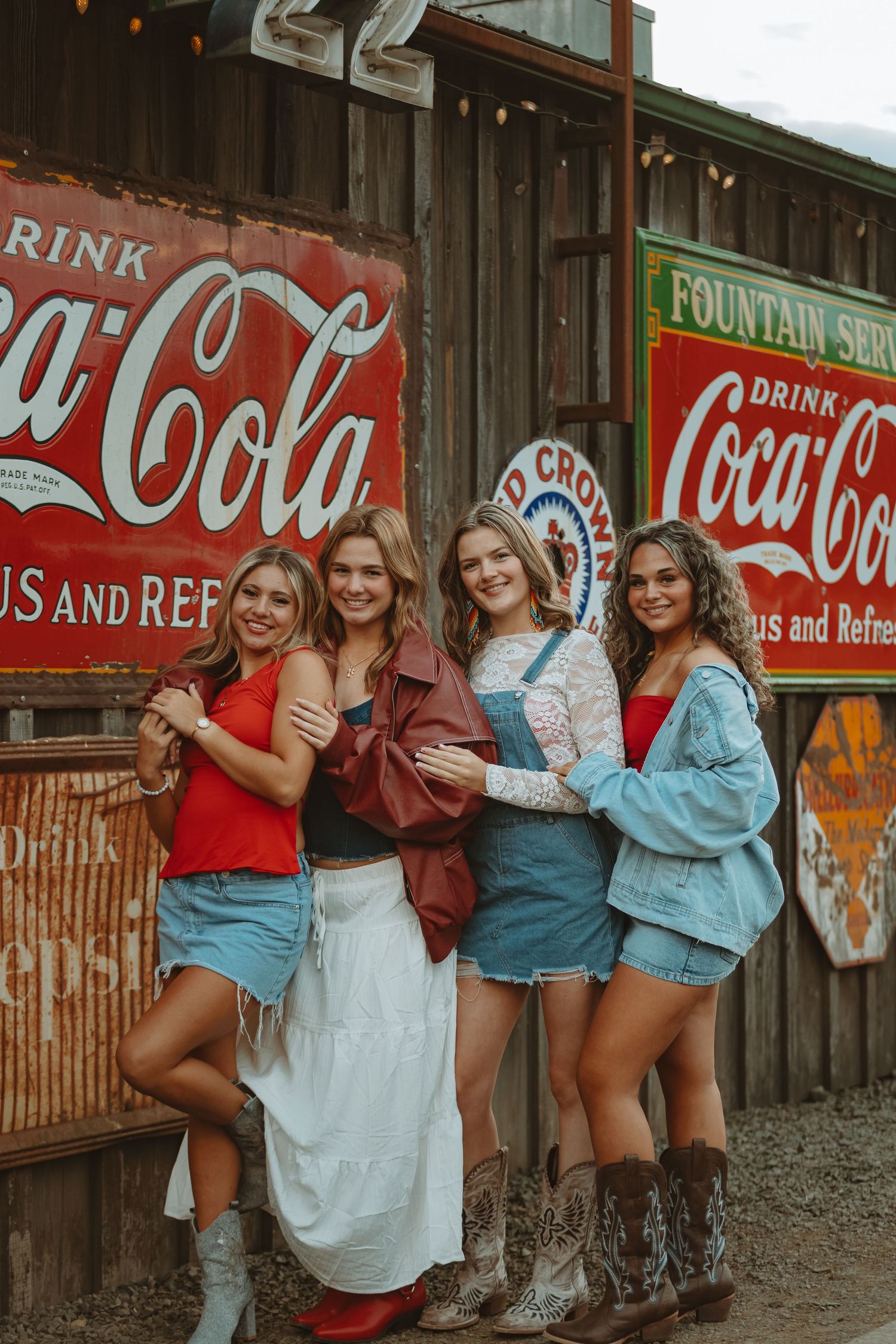 Rustic wall decorated with vintage Coca-Cola and americana signs creates retro atmosphere.