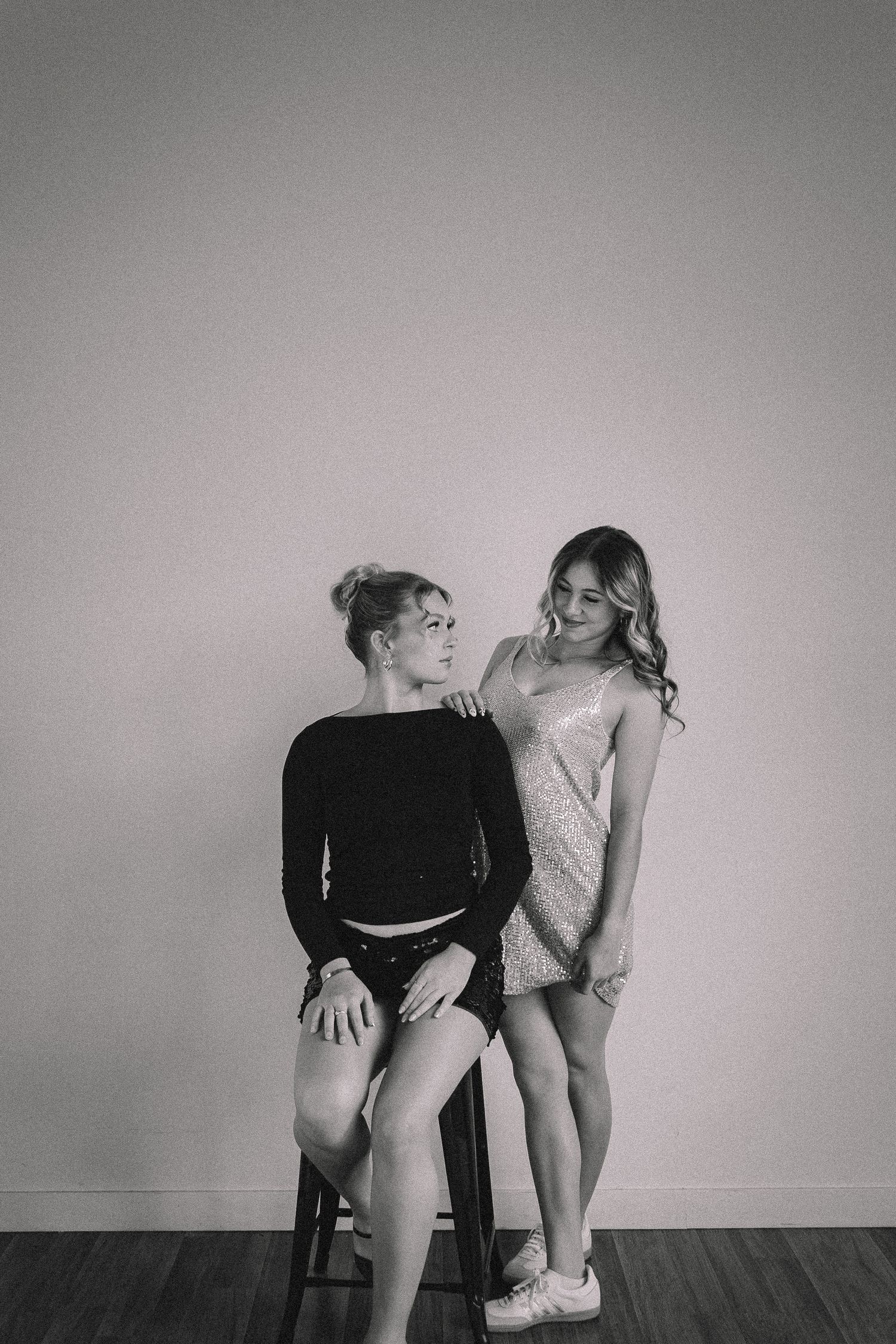 Black and white photo series showing artistic poses with chairs against plain backdrop.
