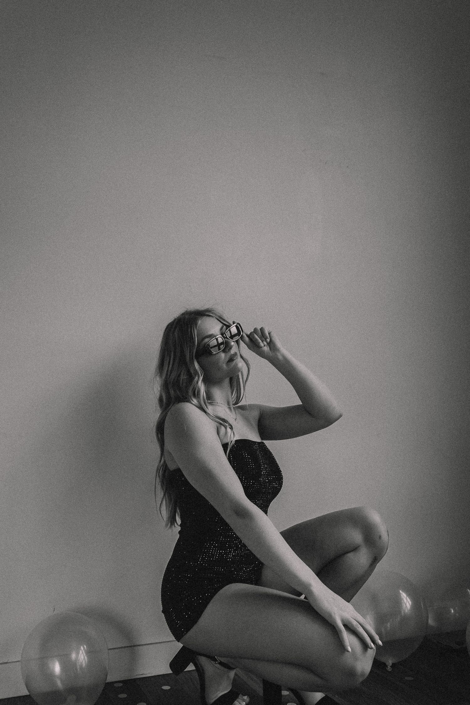 Black and white artistic portrait series with balloons in minimalist setting.