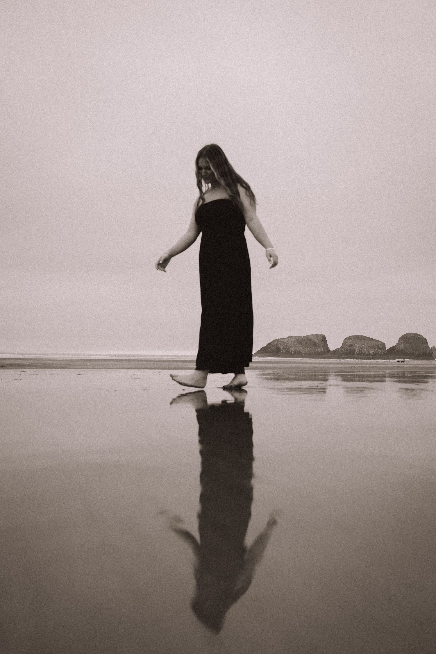 A sequence of black and white photos showing a silhouetted figure walking and reflecting in shallow beach water.