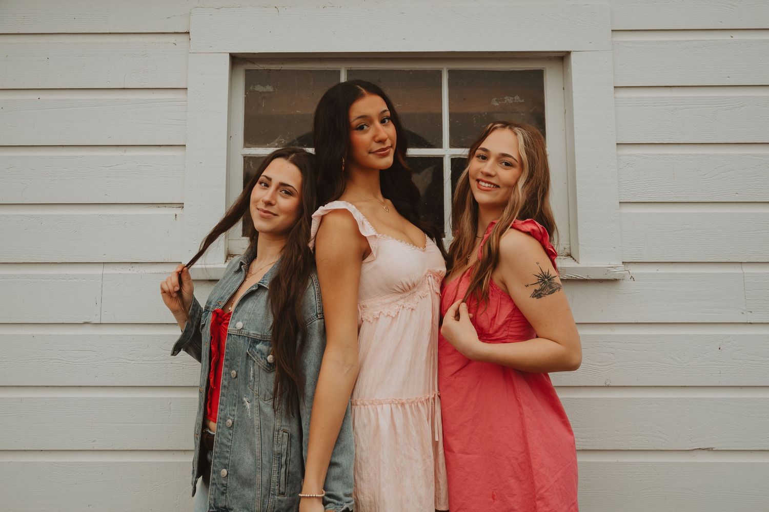 Lifestyle group photography featuring coordinated summer outfits in pink and red tones.
