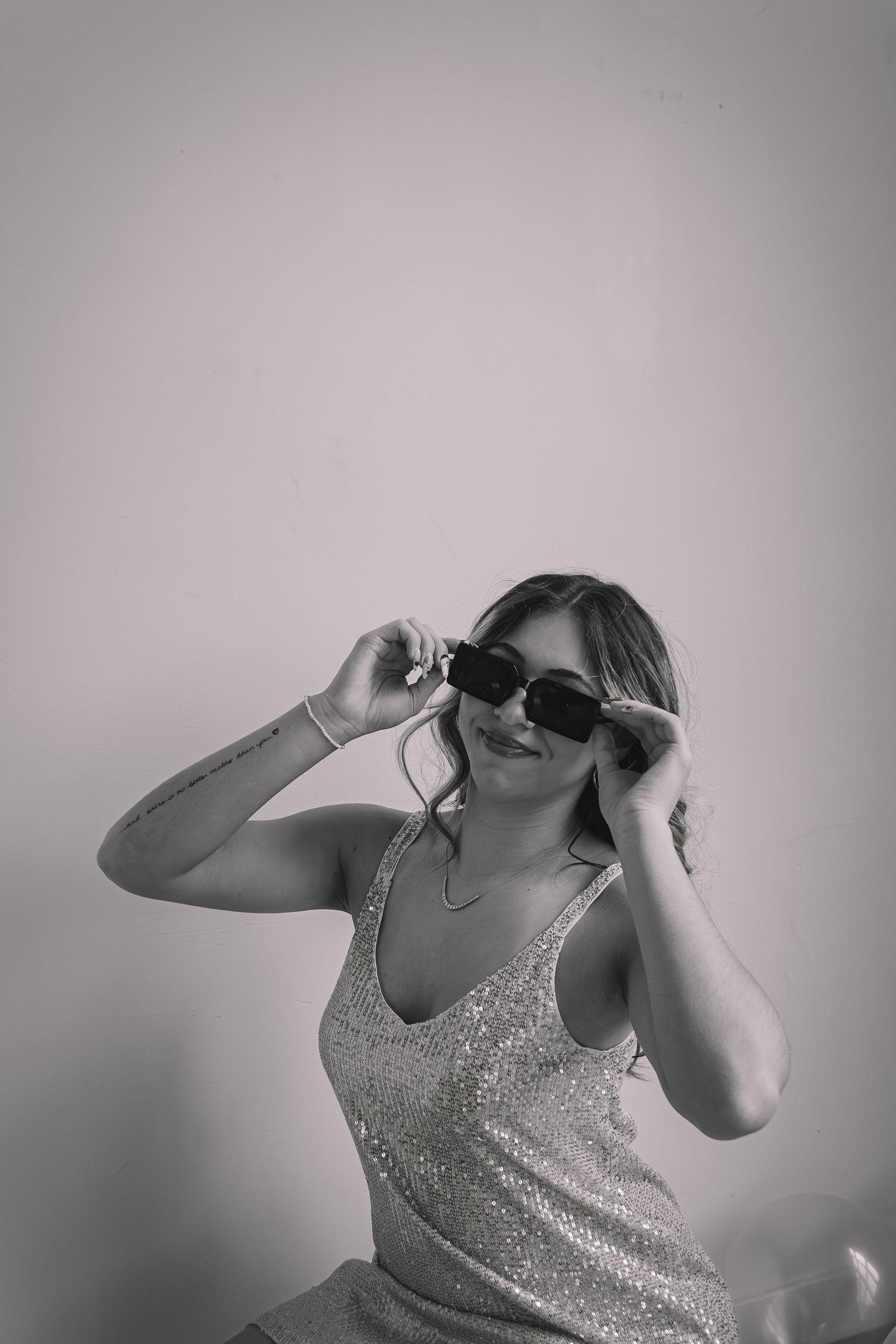 Sequence of black and white photos showing a figure in a sparkly top making playful expressions.