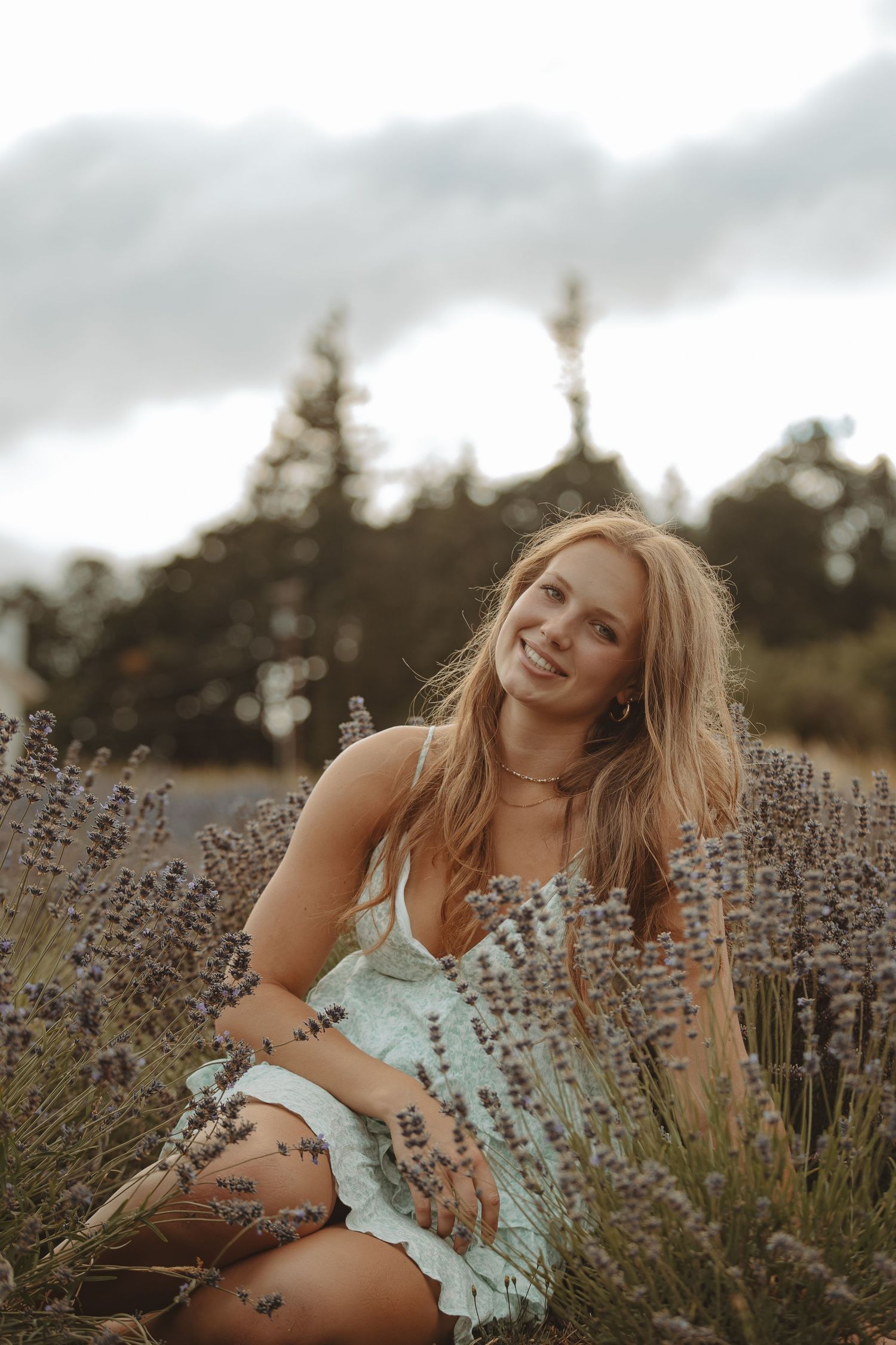 Summer portrait in mint dress surrounded by flowering lavender plants.