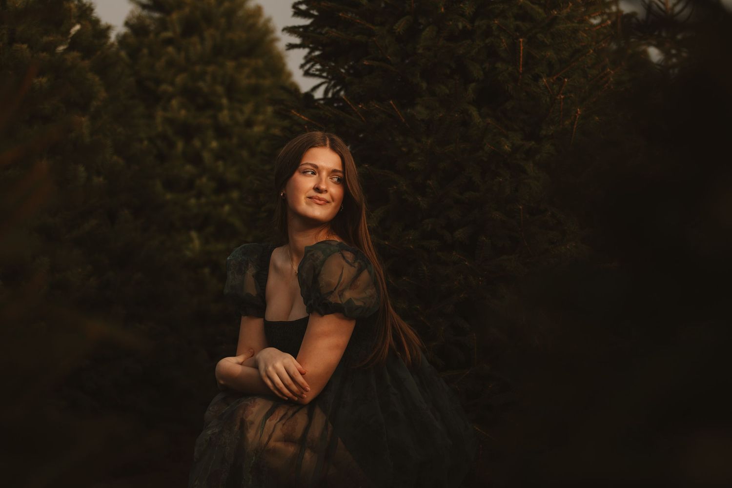 A group shares candid moments while posing against a dark forest backdrop at dusk.