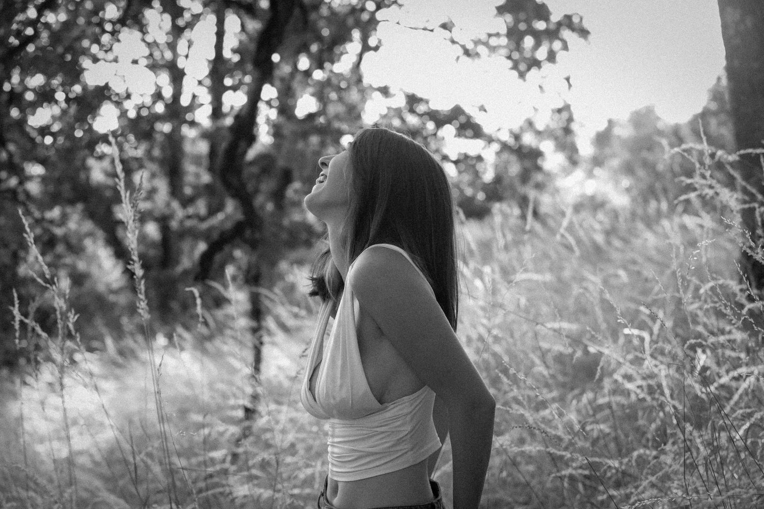 A couple walking together in a dreamy black and white forest setting.
