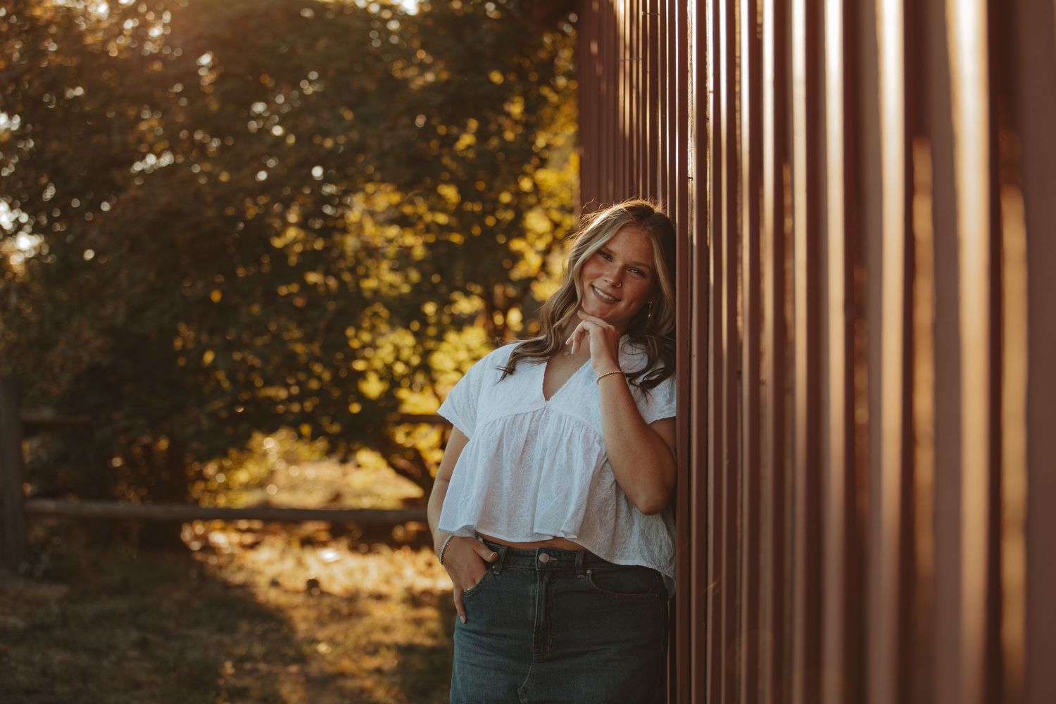 Artistic portrait using wooden columns and natural sunlight.