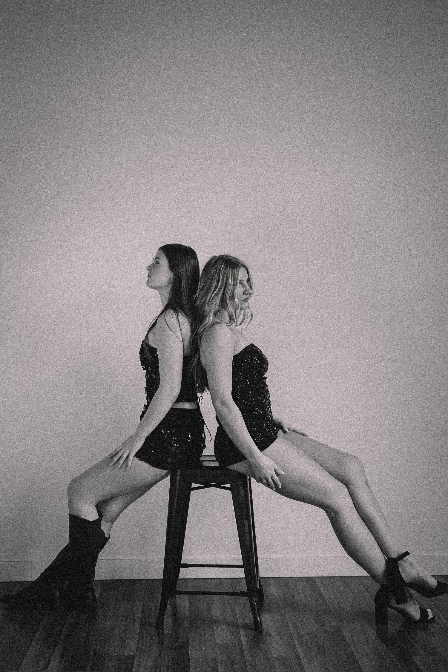 Black and white artistic portrait series of two people posing dramatically on chairs.