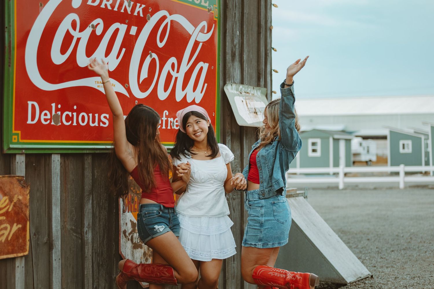 Collection of vintage Coca-Cola advertising signs mounted on weathered wooden wall.
