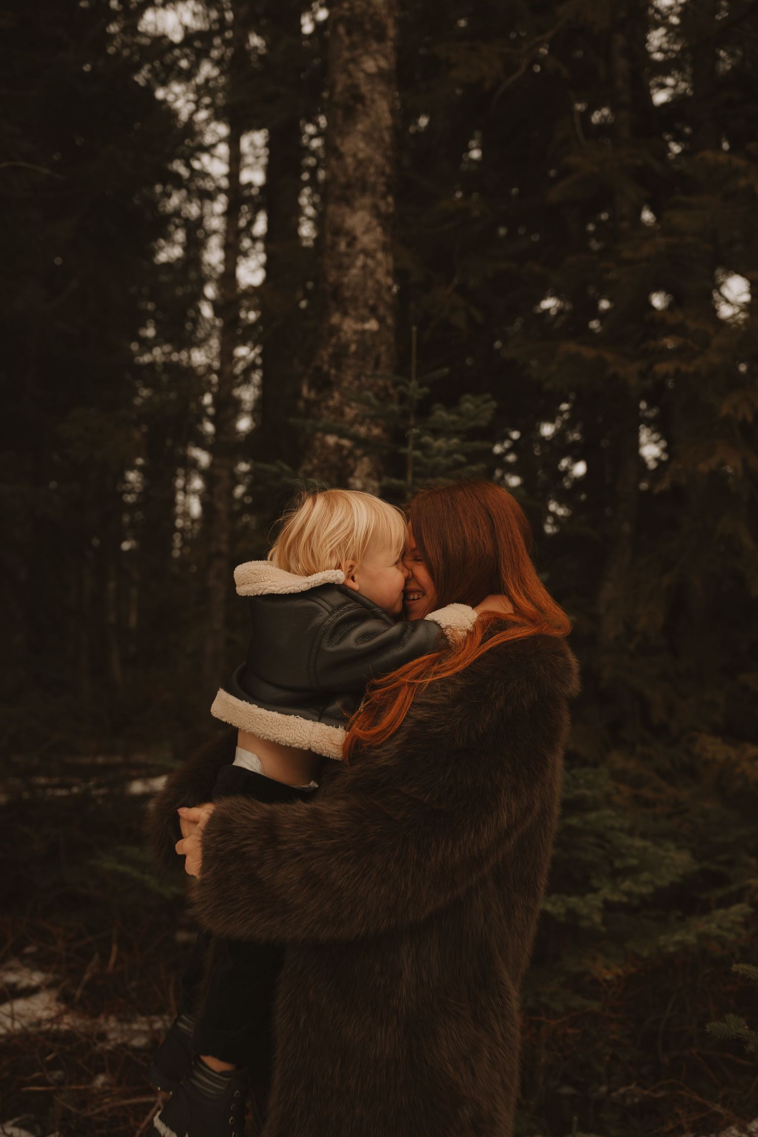 A heartwarming family embrace photographed in a wintry forest landscape.