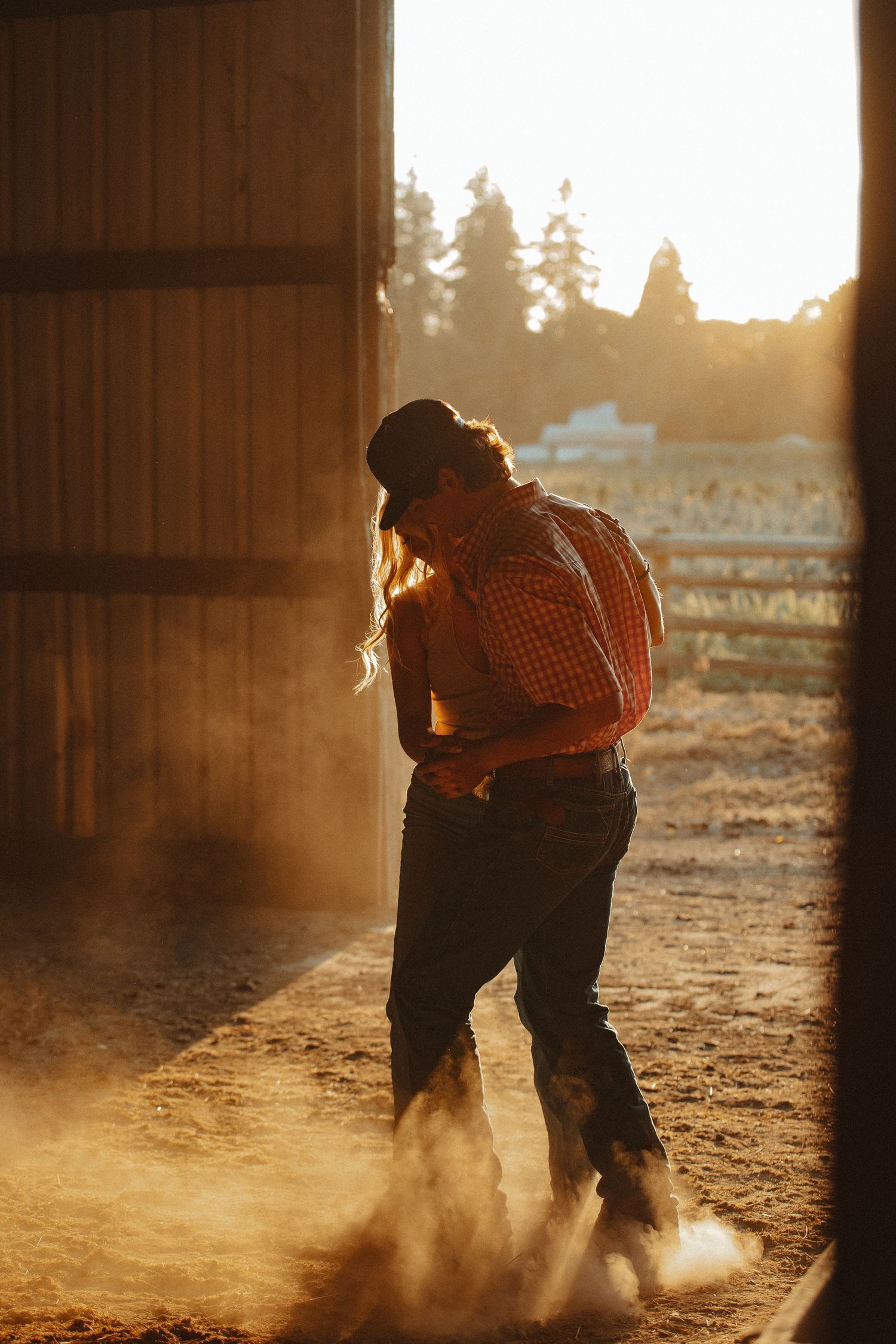 Silhouettes move through dusty barn light creating dramatic shadows on the ground.