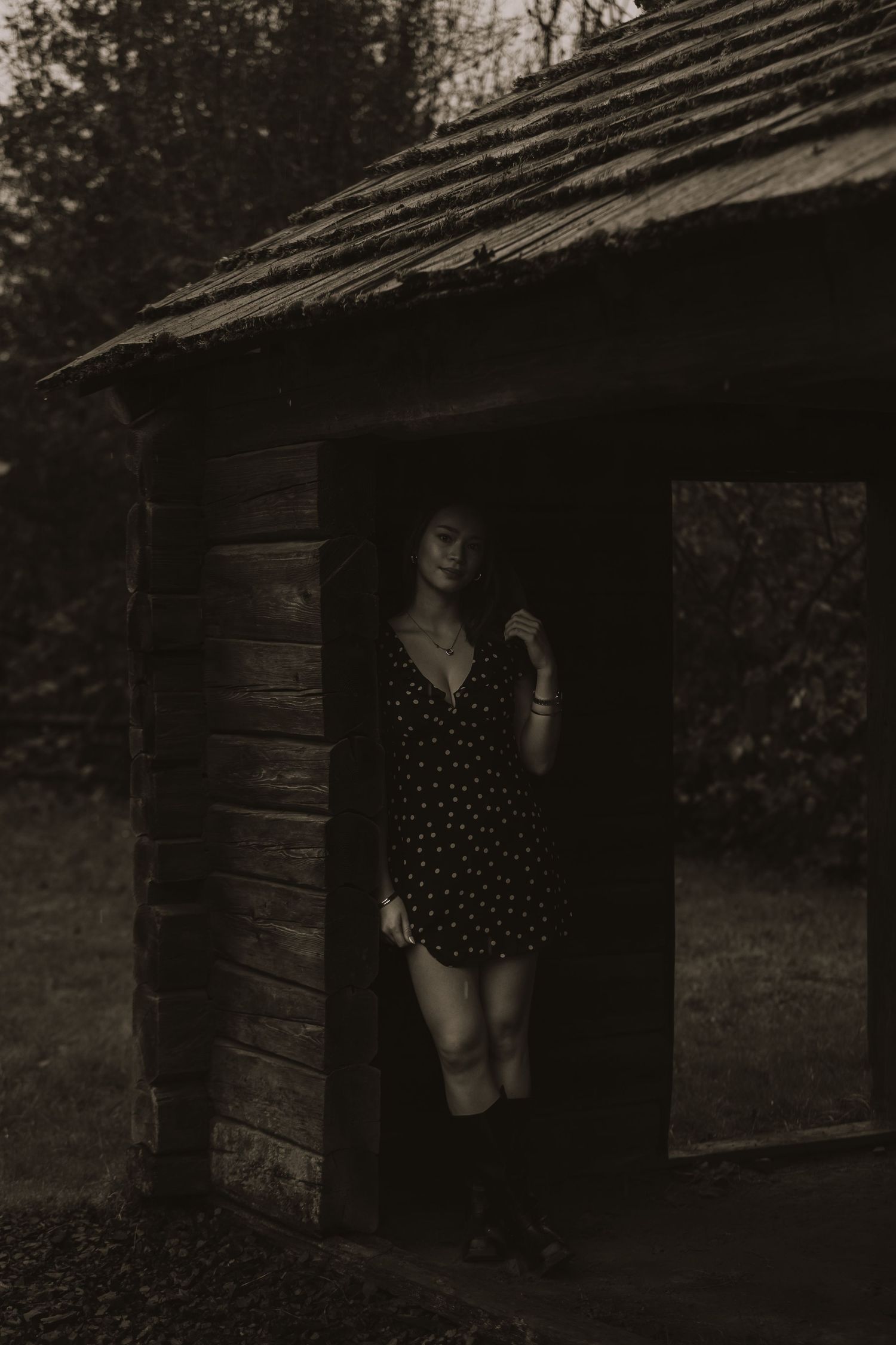 A moody black and white photo sequence showing a figure emerging from a dark wooden doorway in a rustic setting.