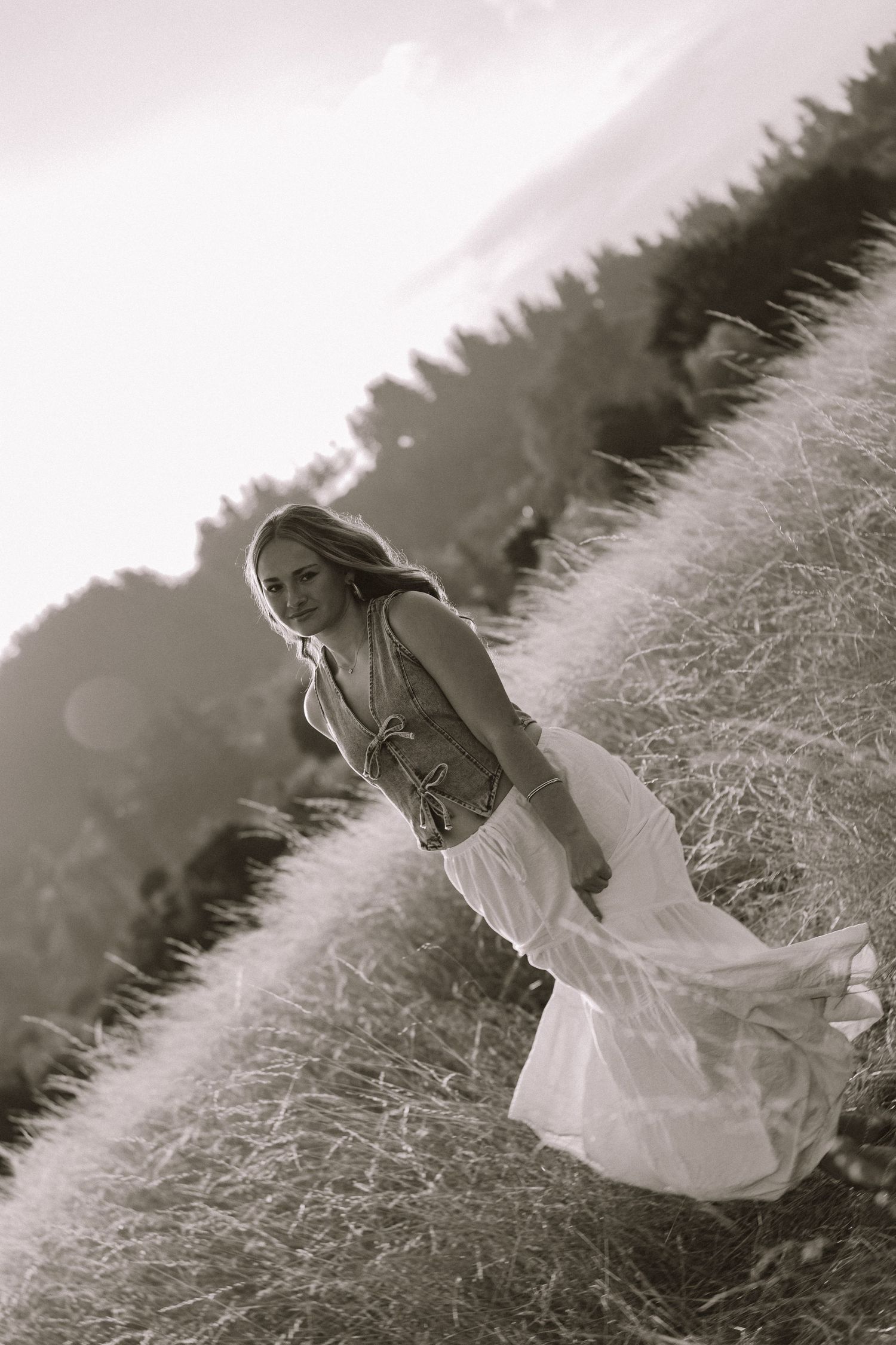 A dreamy black and white photo series showing a flowing white dress twirling in a grassy meadow.