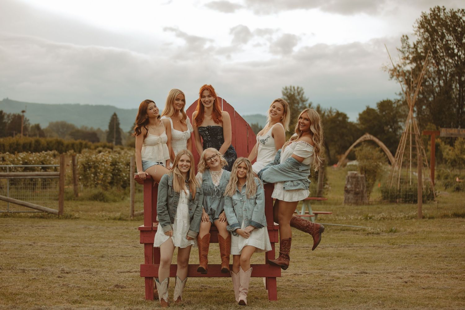 Friends gather for photos in a rustic field setting during golden hour.