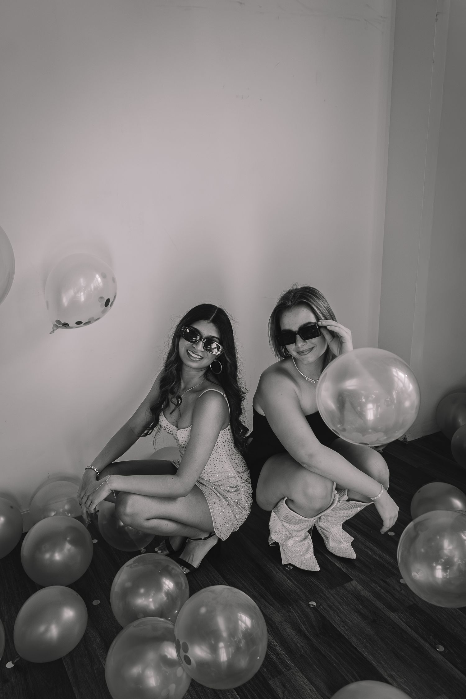 A black and white photo series shows people sitting on a couch with silver balloons in a playful party scene.