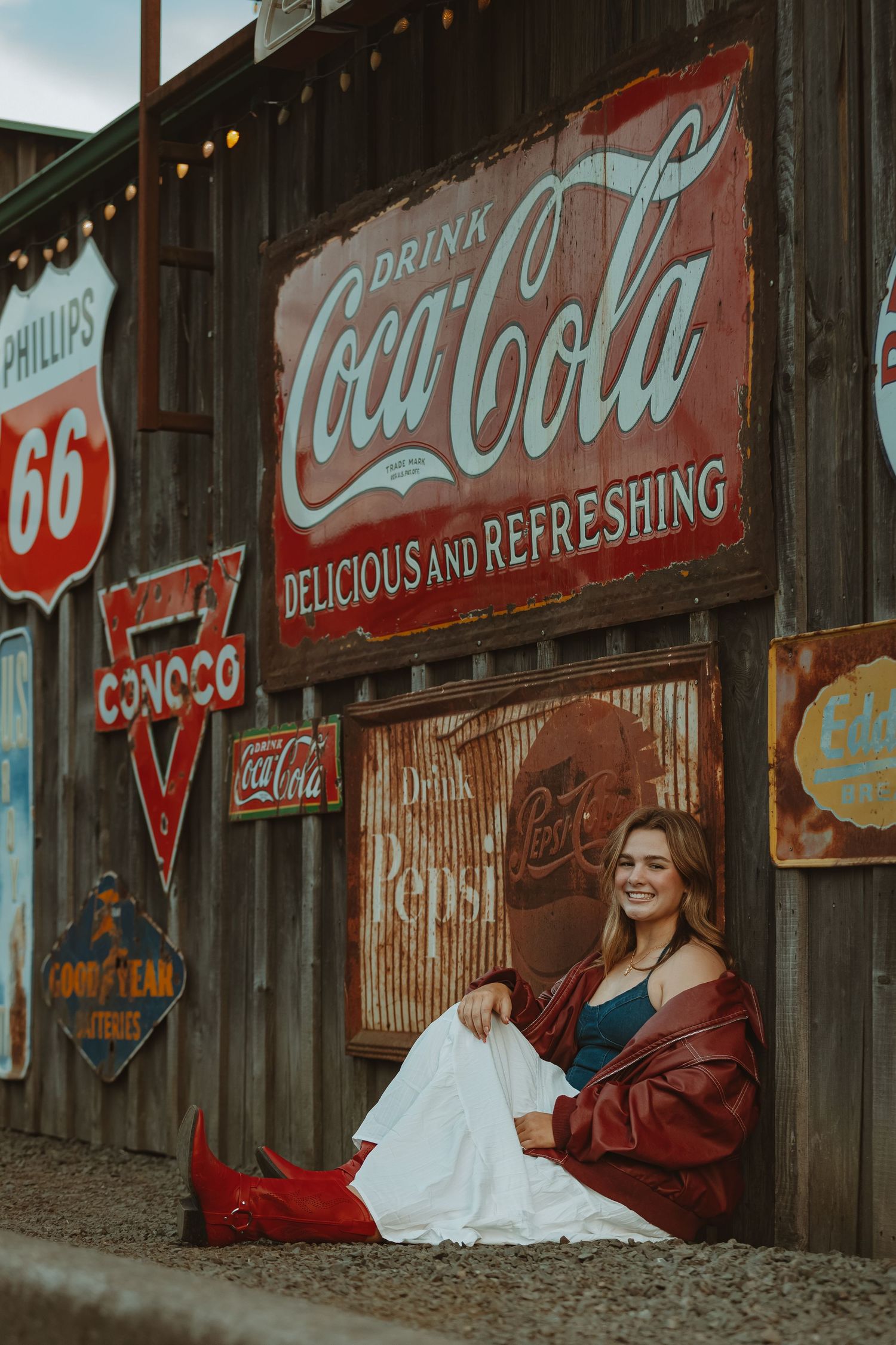 Nostalgic scene with Phillips 66 and Coca-Cola signs on weathered wooden wall.