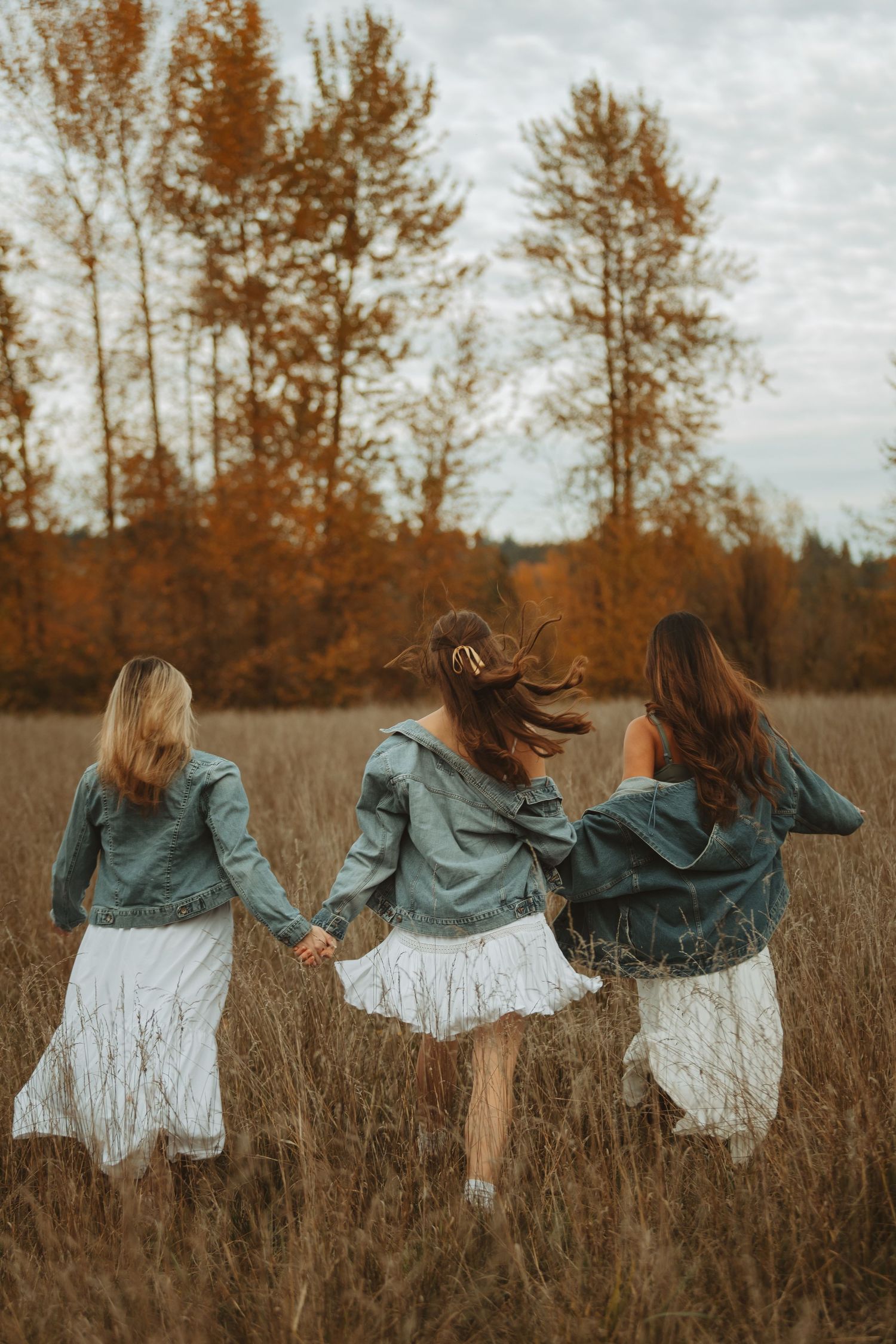 A sequence of artistic photos showing movement in a grassy field with denim jackets and white dresses at sunset.