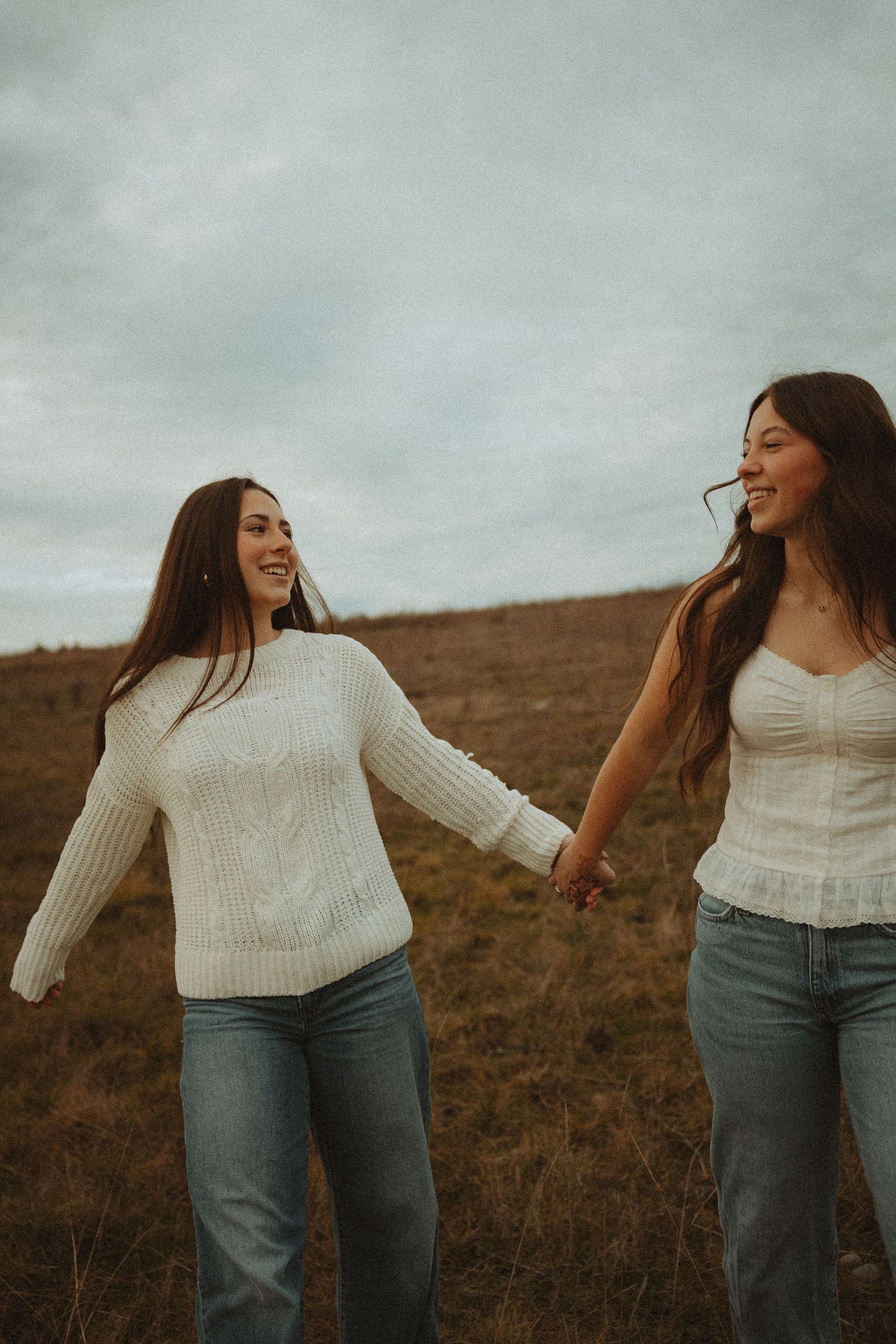 A series of candid moments showing movement and laughter in white sweaters against an autumn landscape.