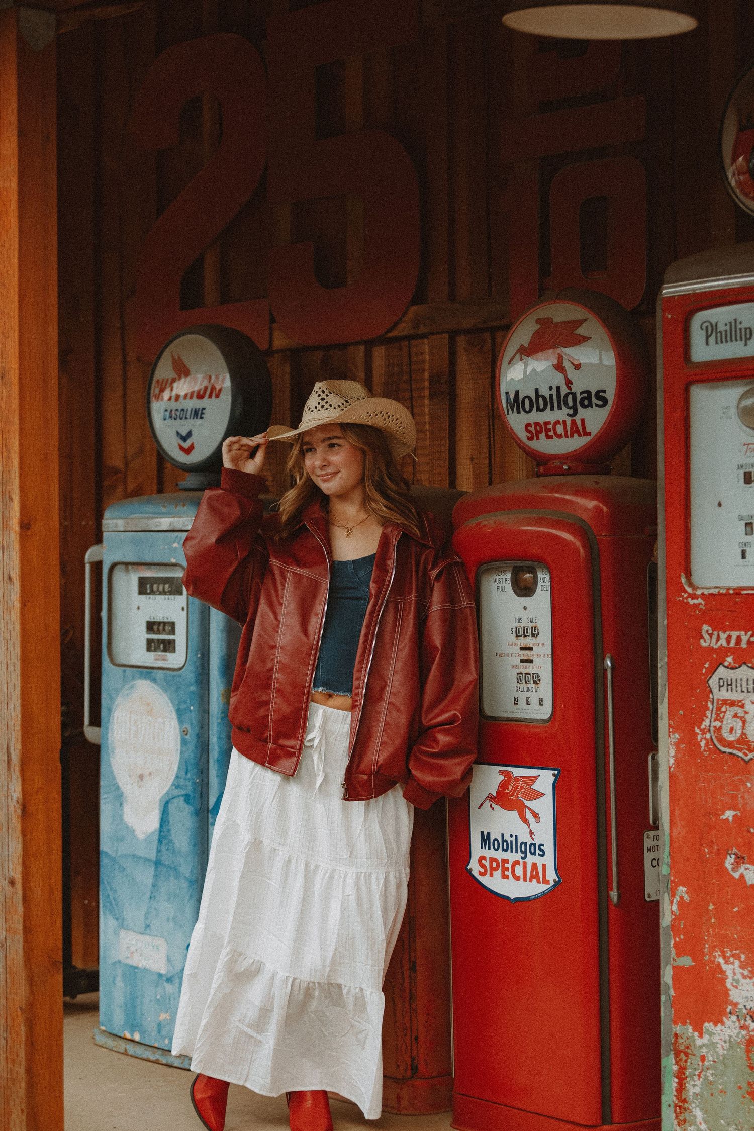 Retro gas station display with vintage Mobilgas pumps and red metal signs.