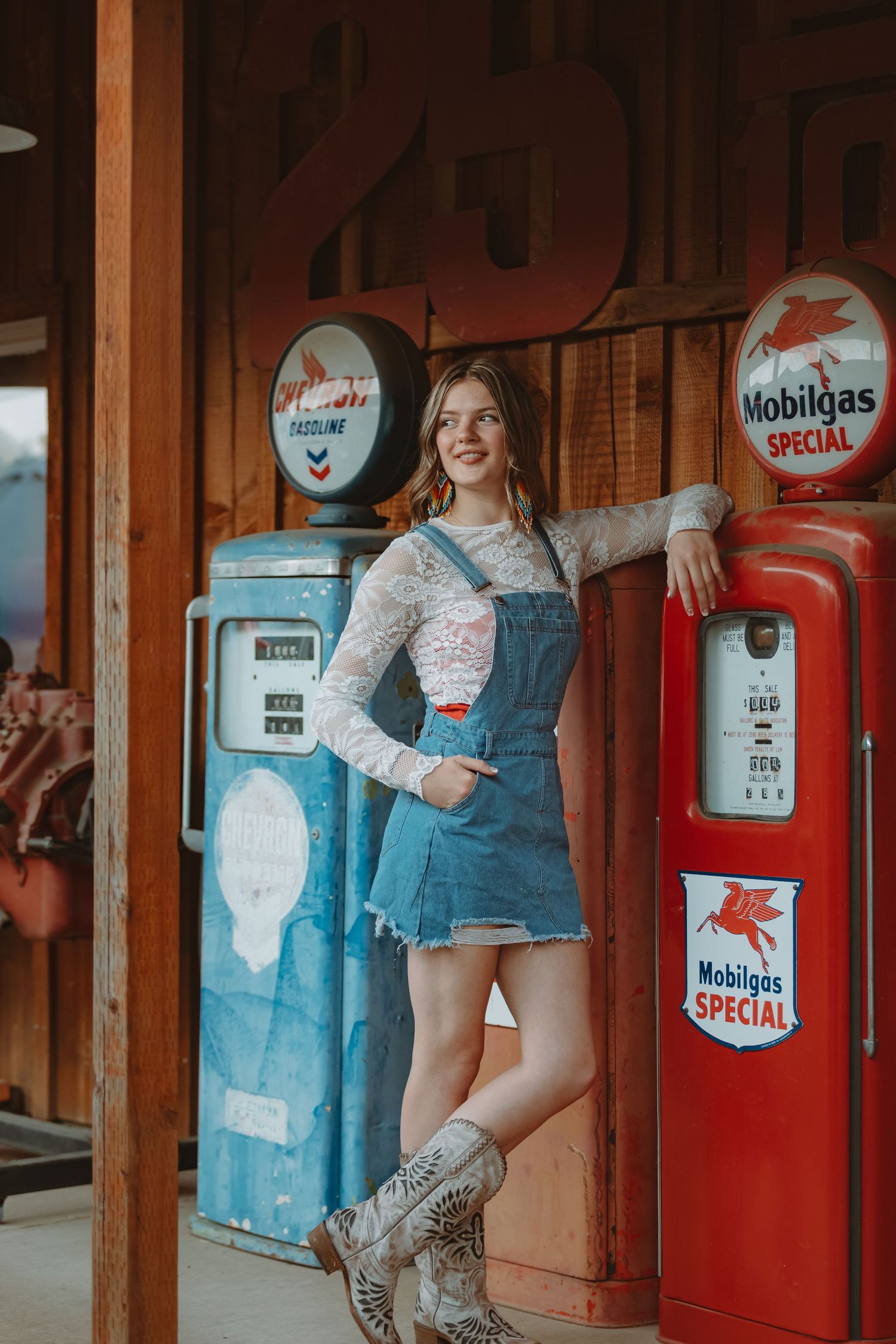Nostalgic scene at an old gas station with blue and red vintage pumps and wooden posts.