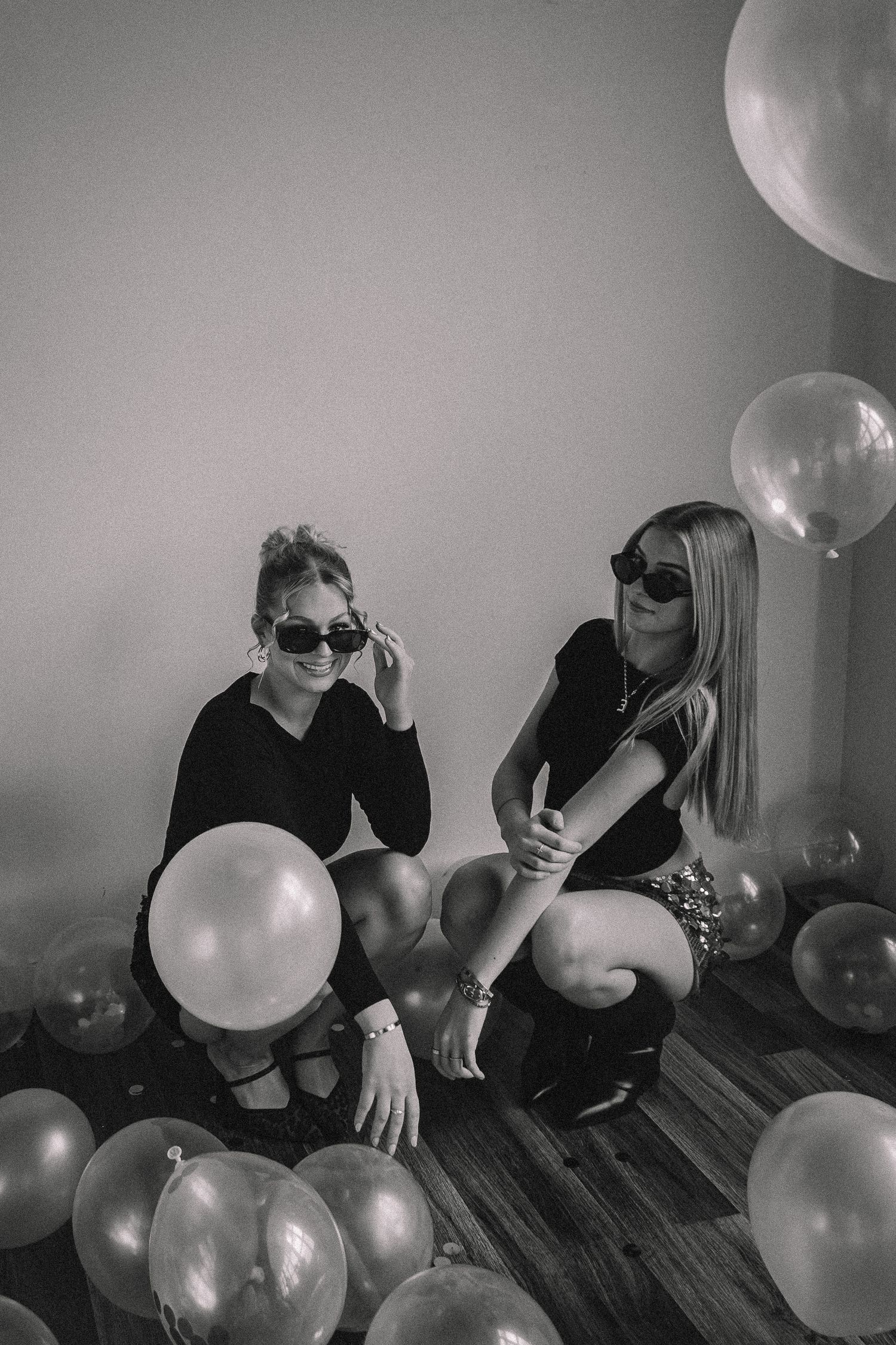 Artistic black and white photo sequence with balloons on hardwood floor.