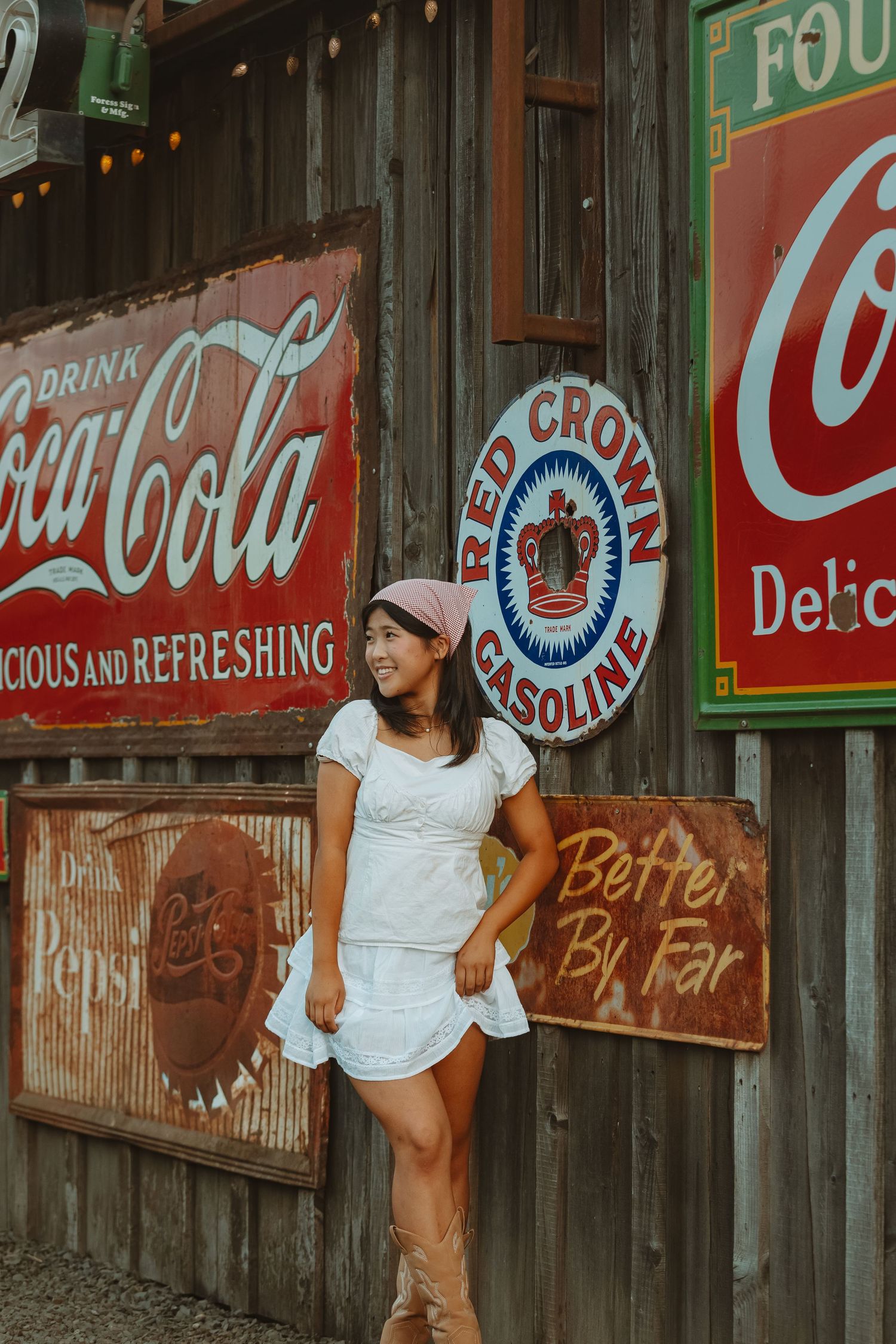 Vintage advertising wall featuring classic Coca-Cola and Red Crown Gasoline signs.