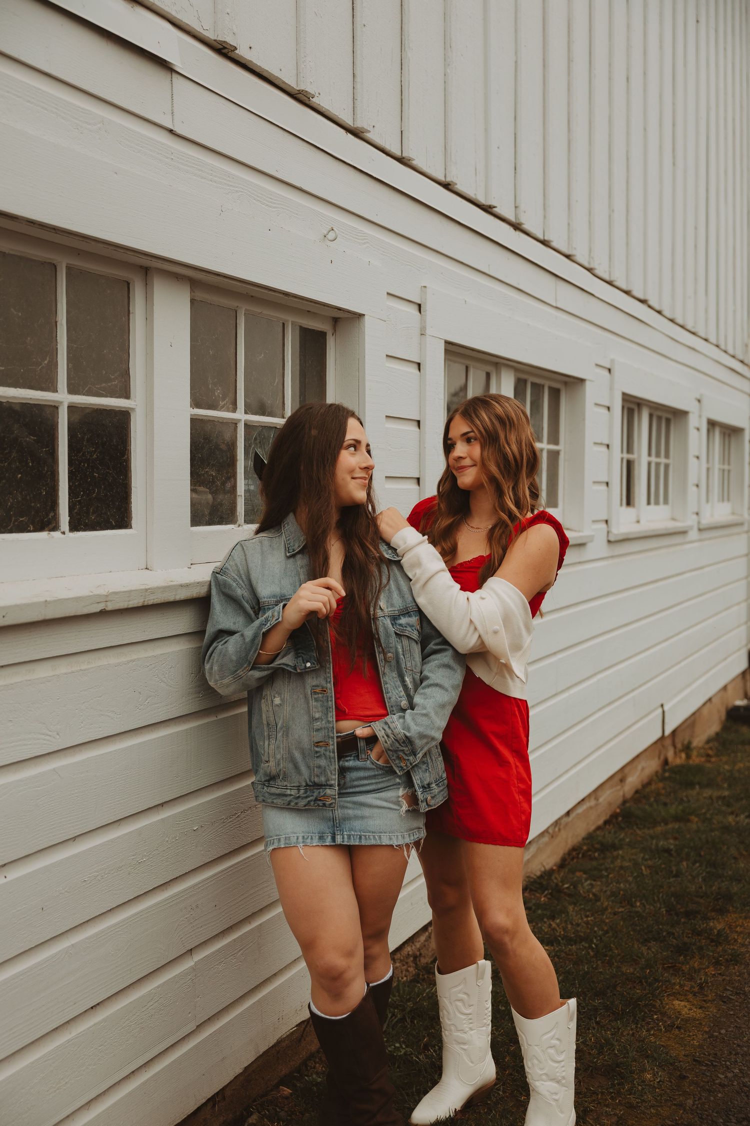 Two outfits featuring denim and red styled against white architectural background.