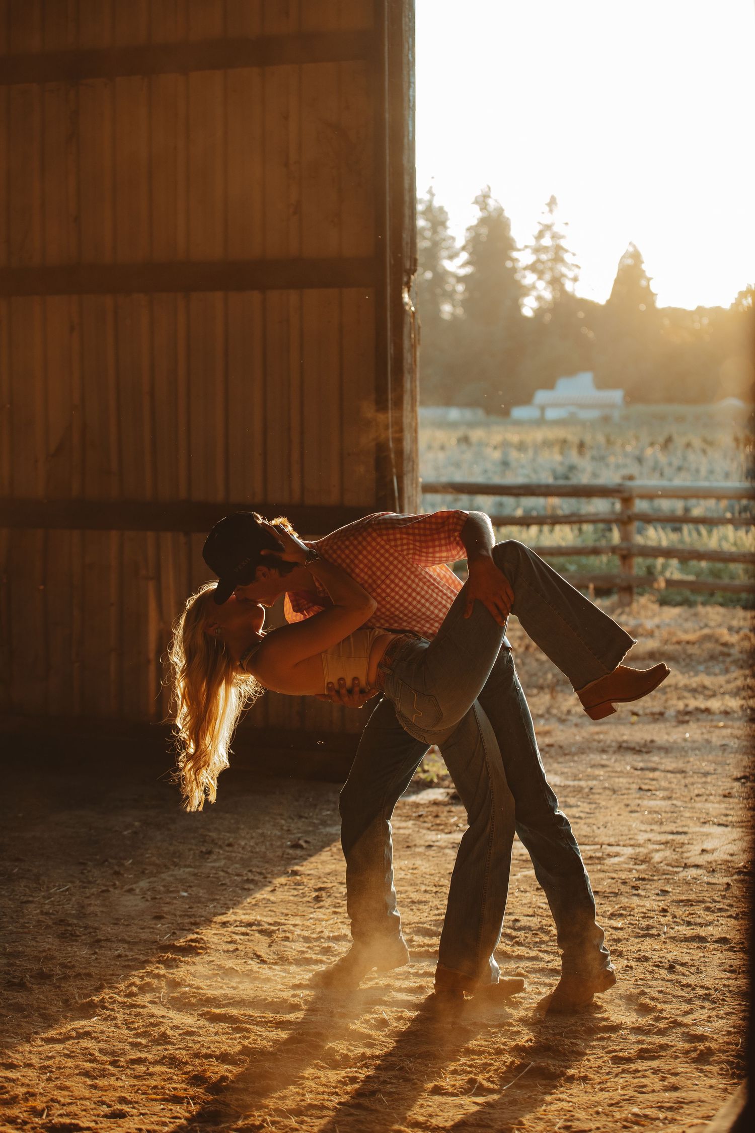 Sunlit dust particles dance around two figures in a barn during golden hour.