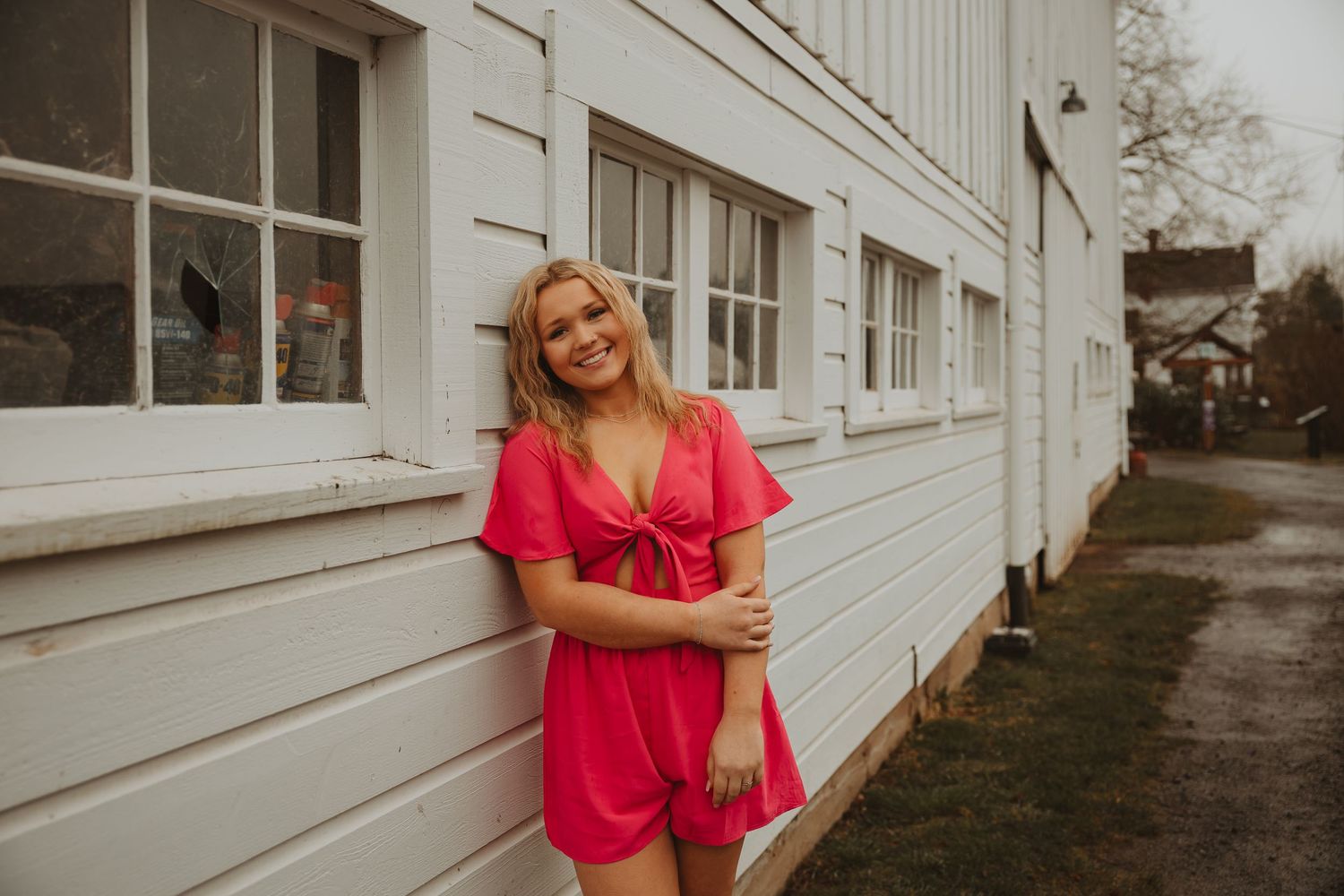 A series of five photos showing someone in a bright red dress posing against a white building exterior.