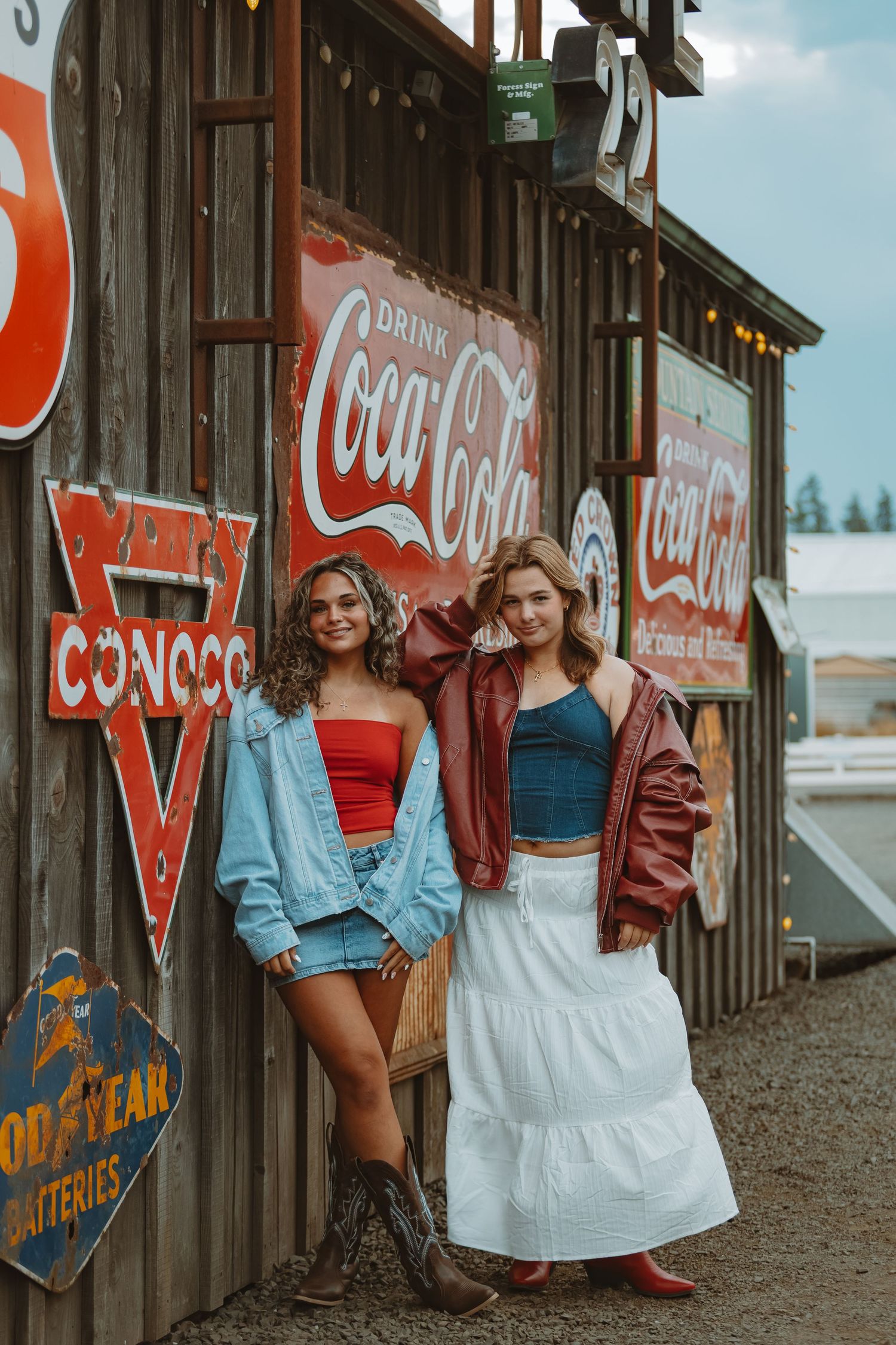 Vintage Coca-Cola signs and advertisements decorate a rustic wooden wall.