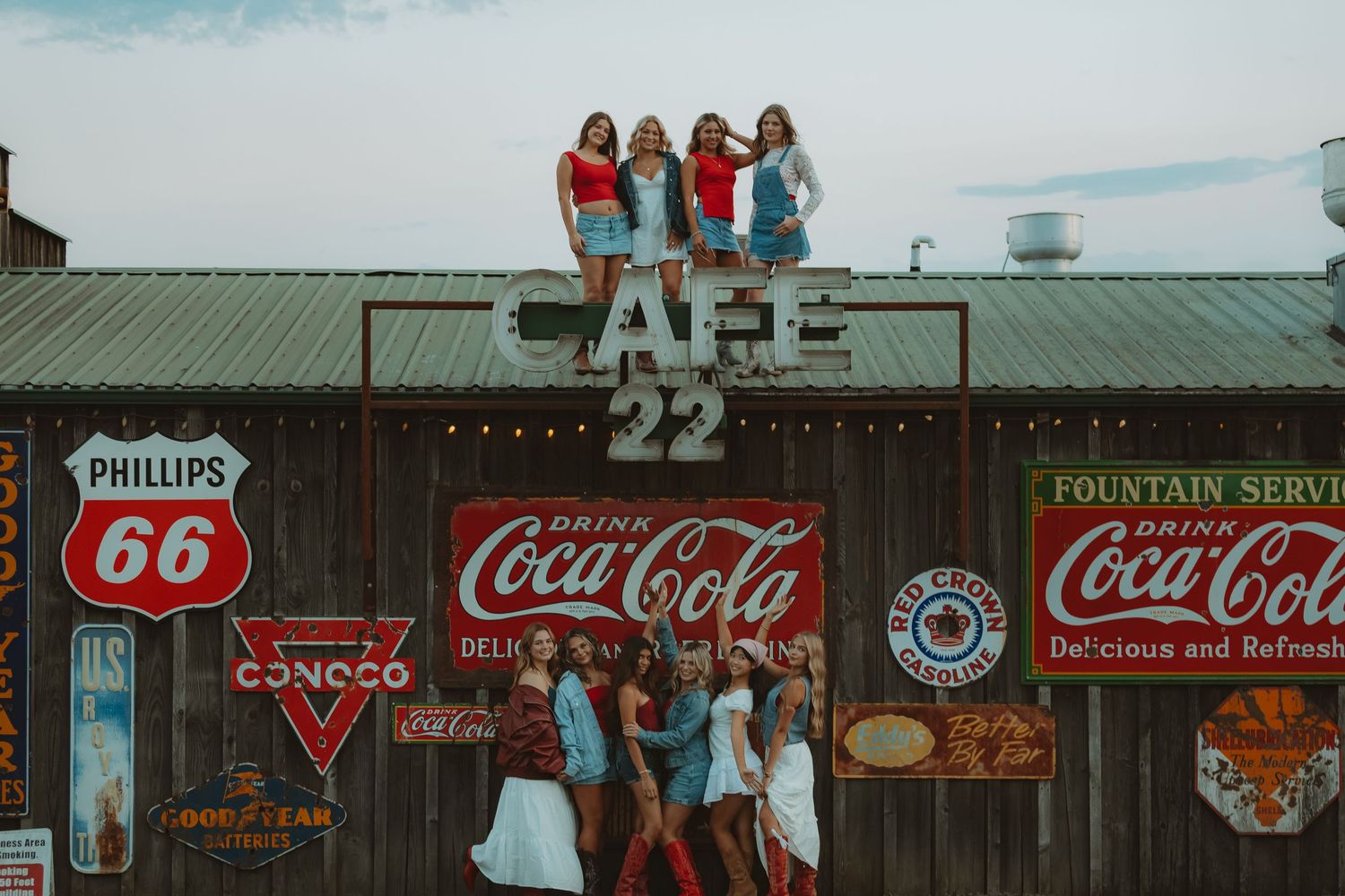 Vintage storefront with retro Coca-Cola and Phillips 66 signage displayed on wooden walls.