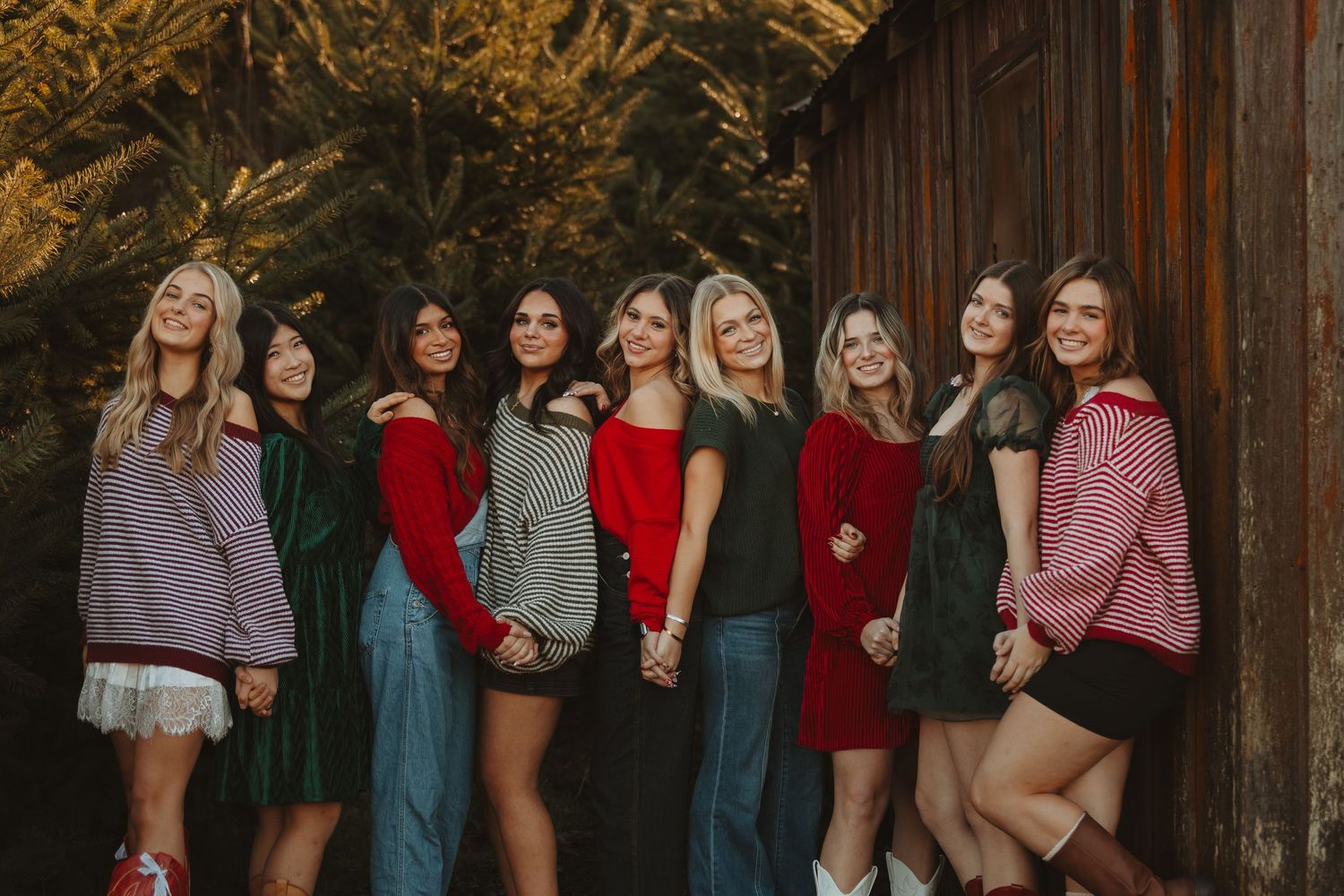 Group photo session against rustic wooden barn wall in casual winter attire.
