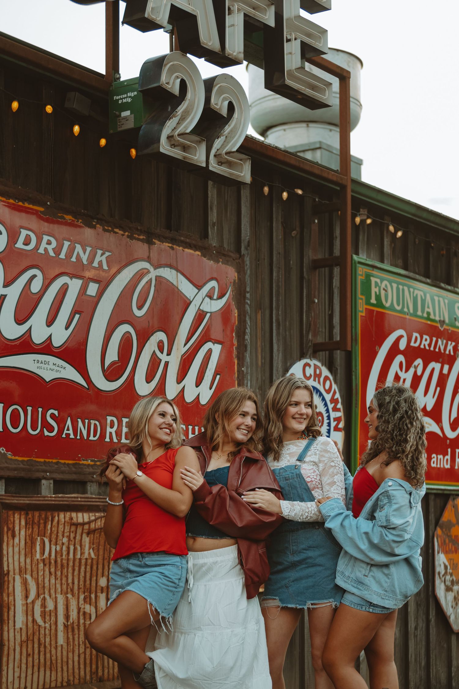 Vintage Coca-Cola fountain service signs create nostalgic backdrop against wooden wall.