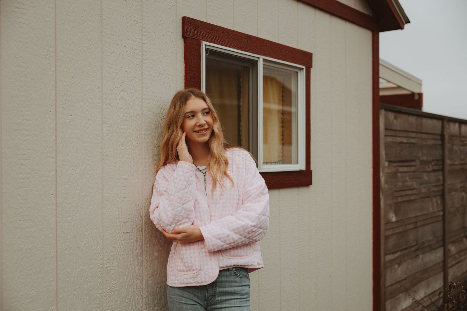 Fashion portraits against white siding featuring soft pink spring clothing.