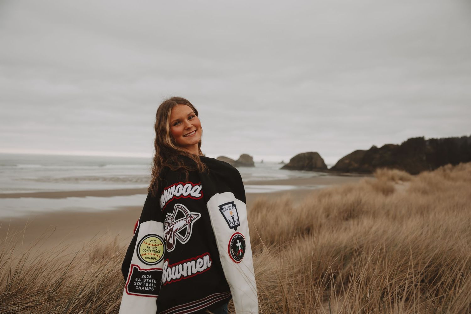 Coastal landscape with grassy dunes and cloudy skies along a rugged Pacific Northwest beach.