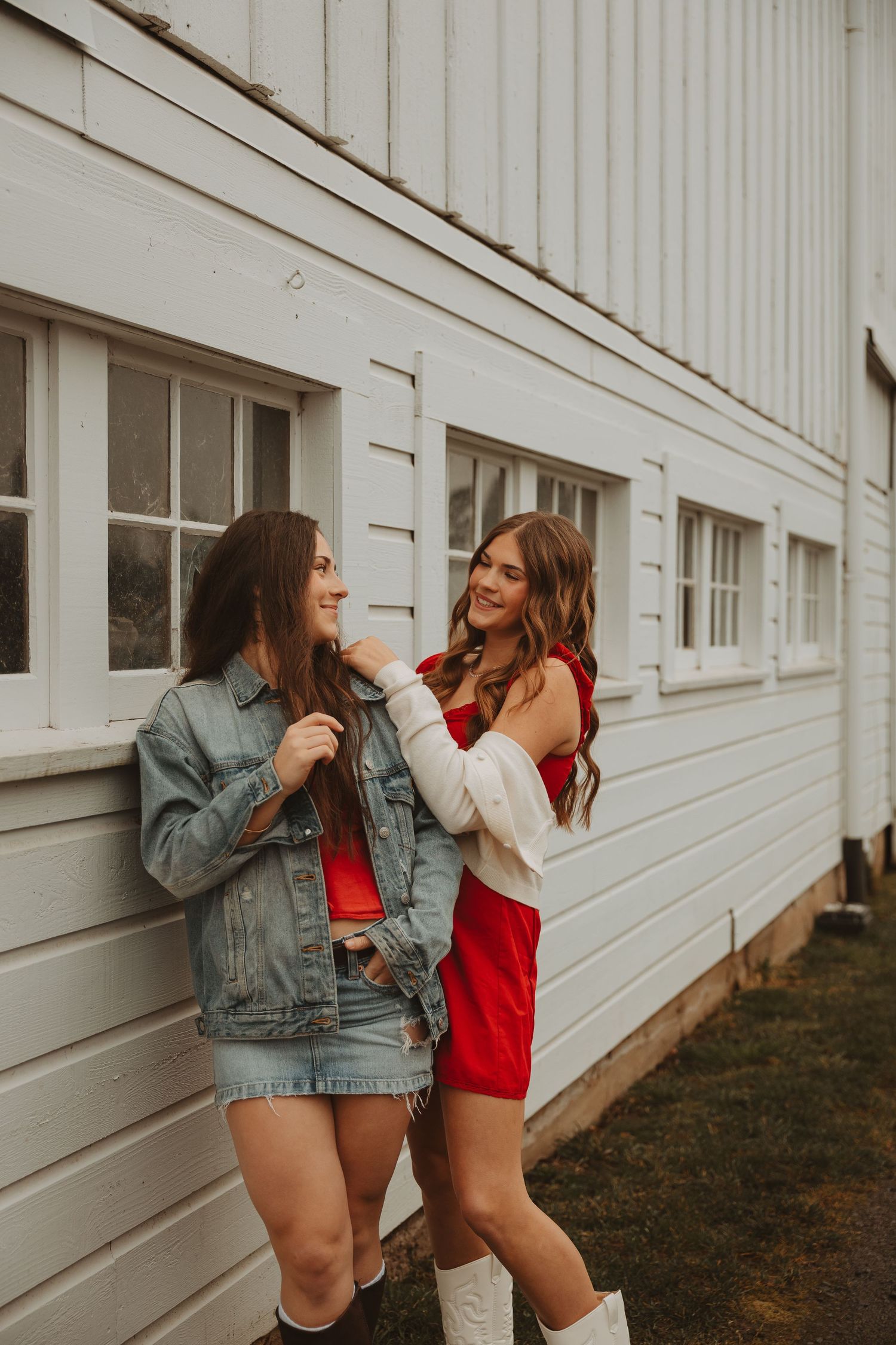 Friends in casual outfits laugh and pose together against a white building exterior.