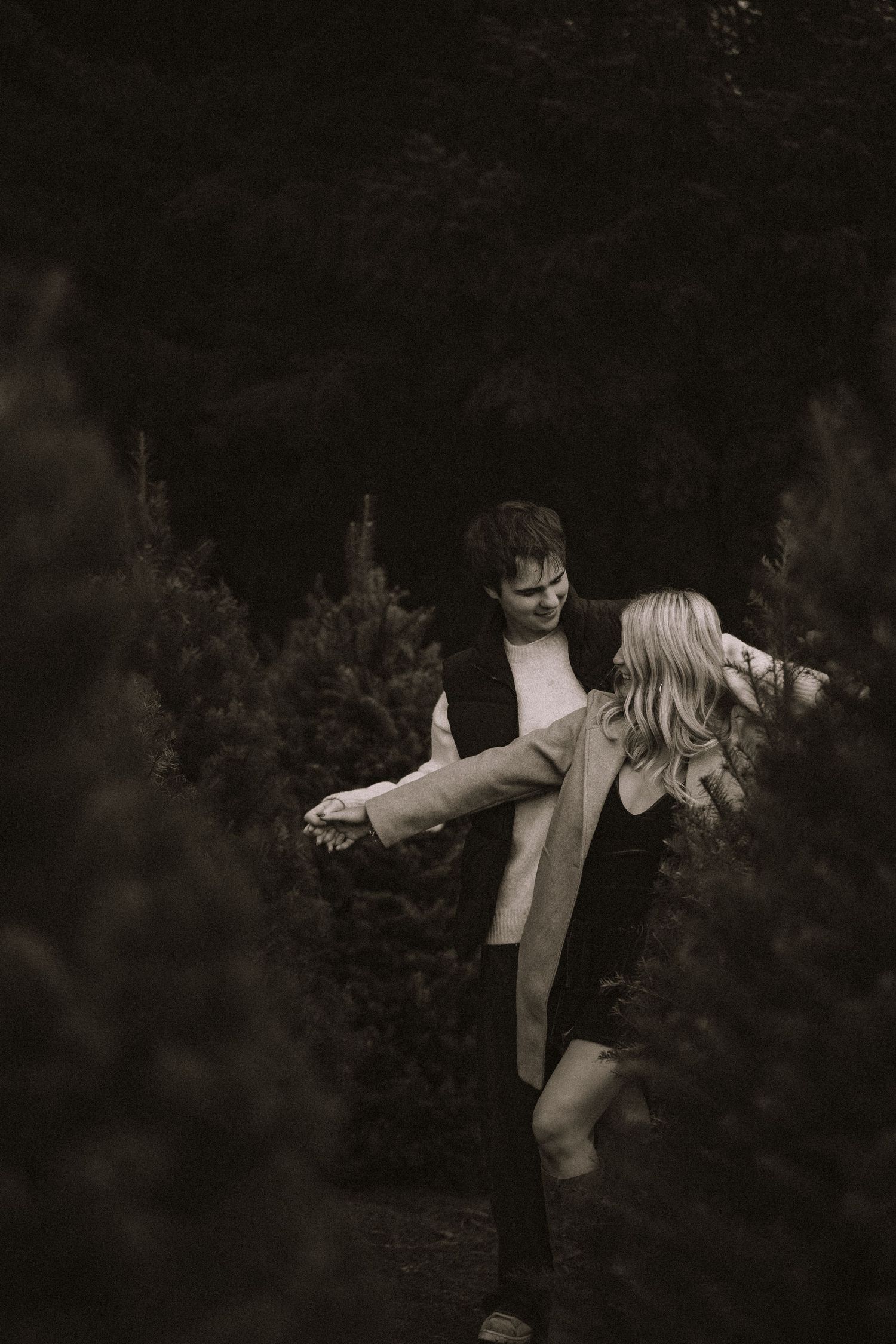 Romantic silhouette of a couple dancing together in a dark, intimate outdoor setting.