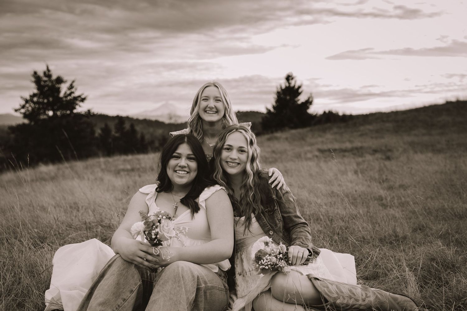 A series of black and white photographs showing people relaxing and posing together in an outdoor field setting.