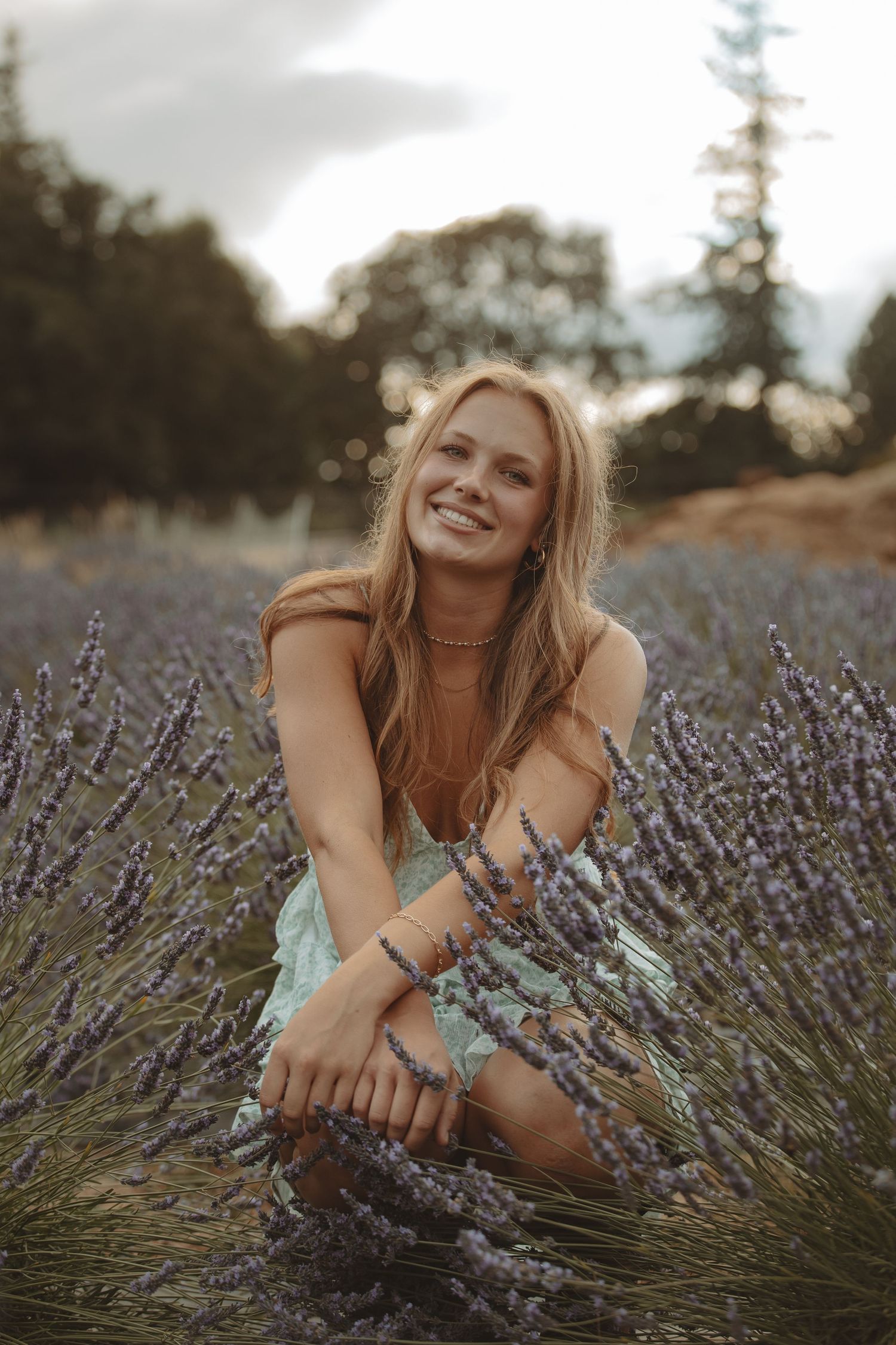 Natural light portrait among fragrant lavender blooms with soft lighting.
