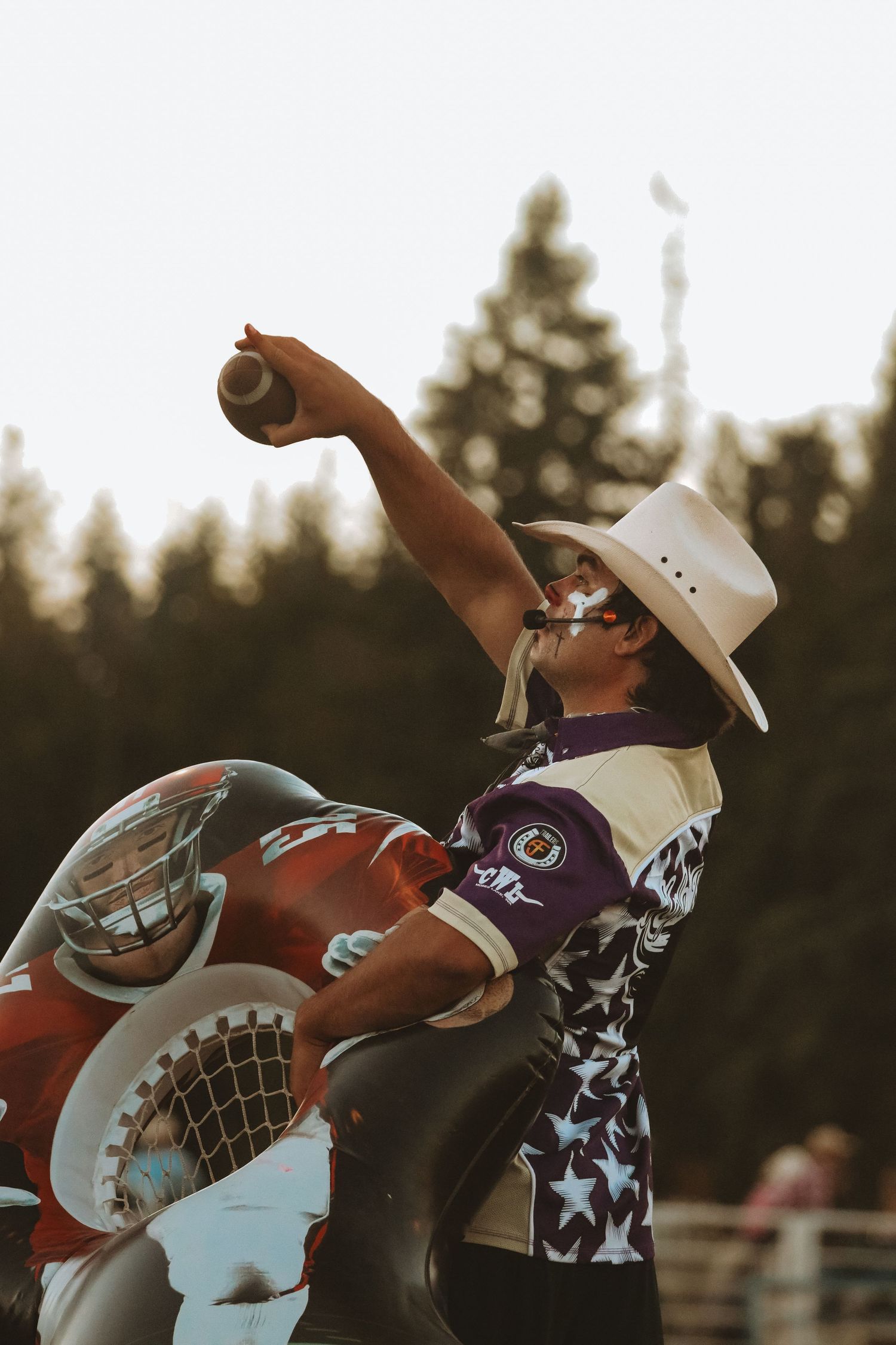 Mechanical bull riding action shot captured during sunset at rodeo event.