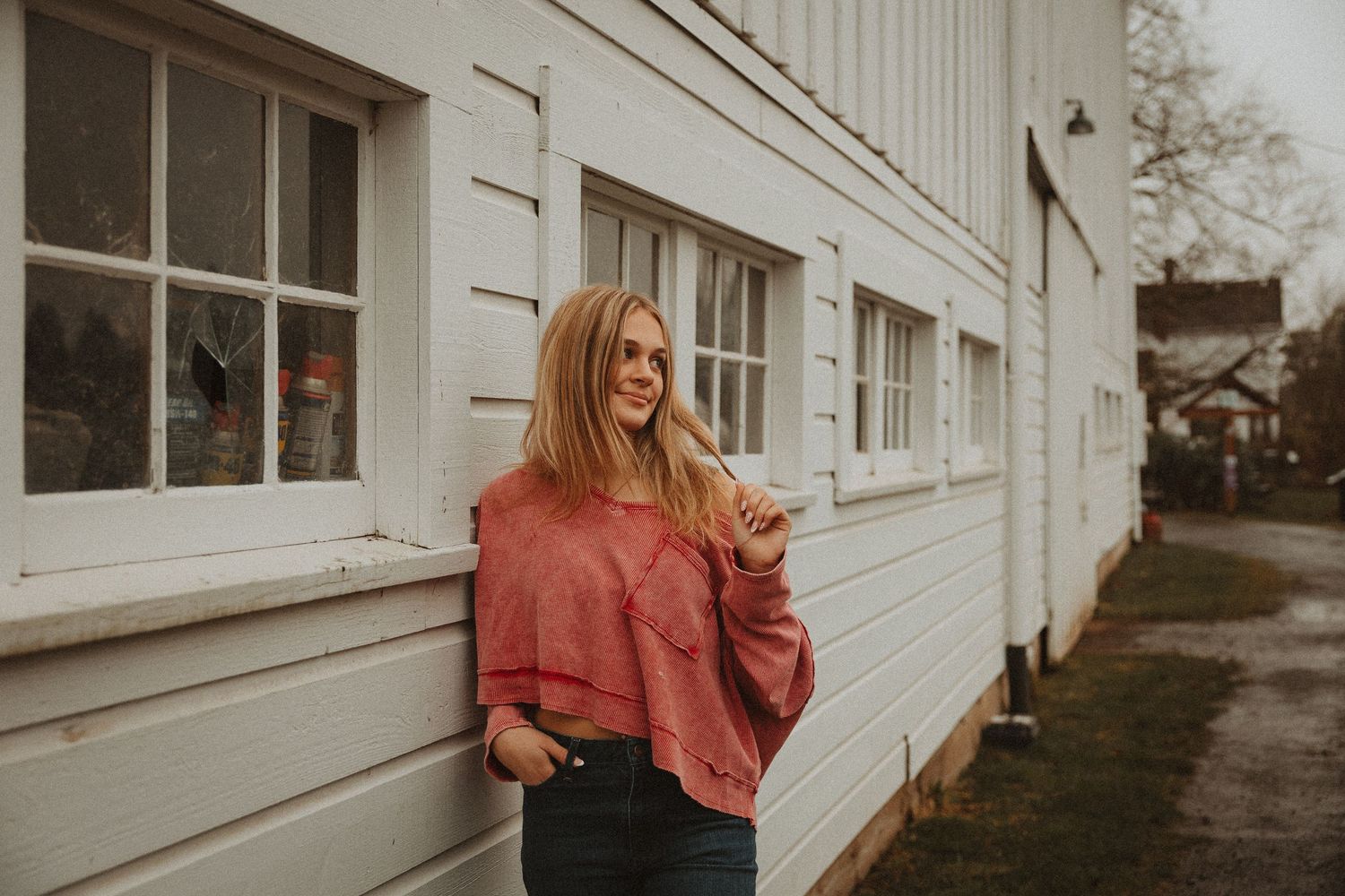 Lifestyle fashion photography with coral colored tops against white architectural backdrop.