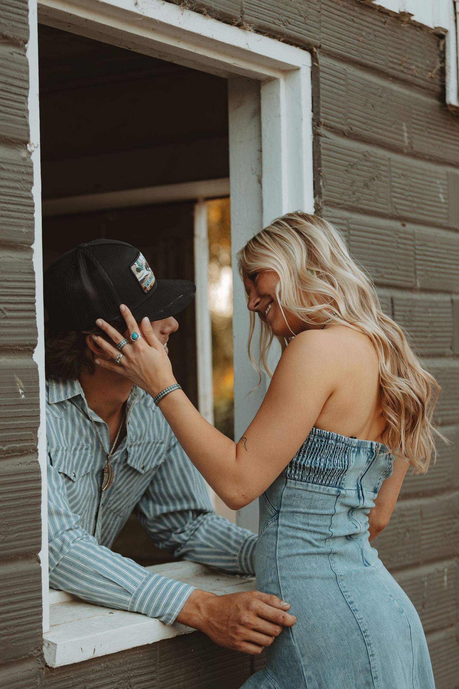 A playful moment captured through barn windows during a rustic photoshoot.