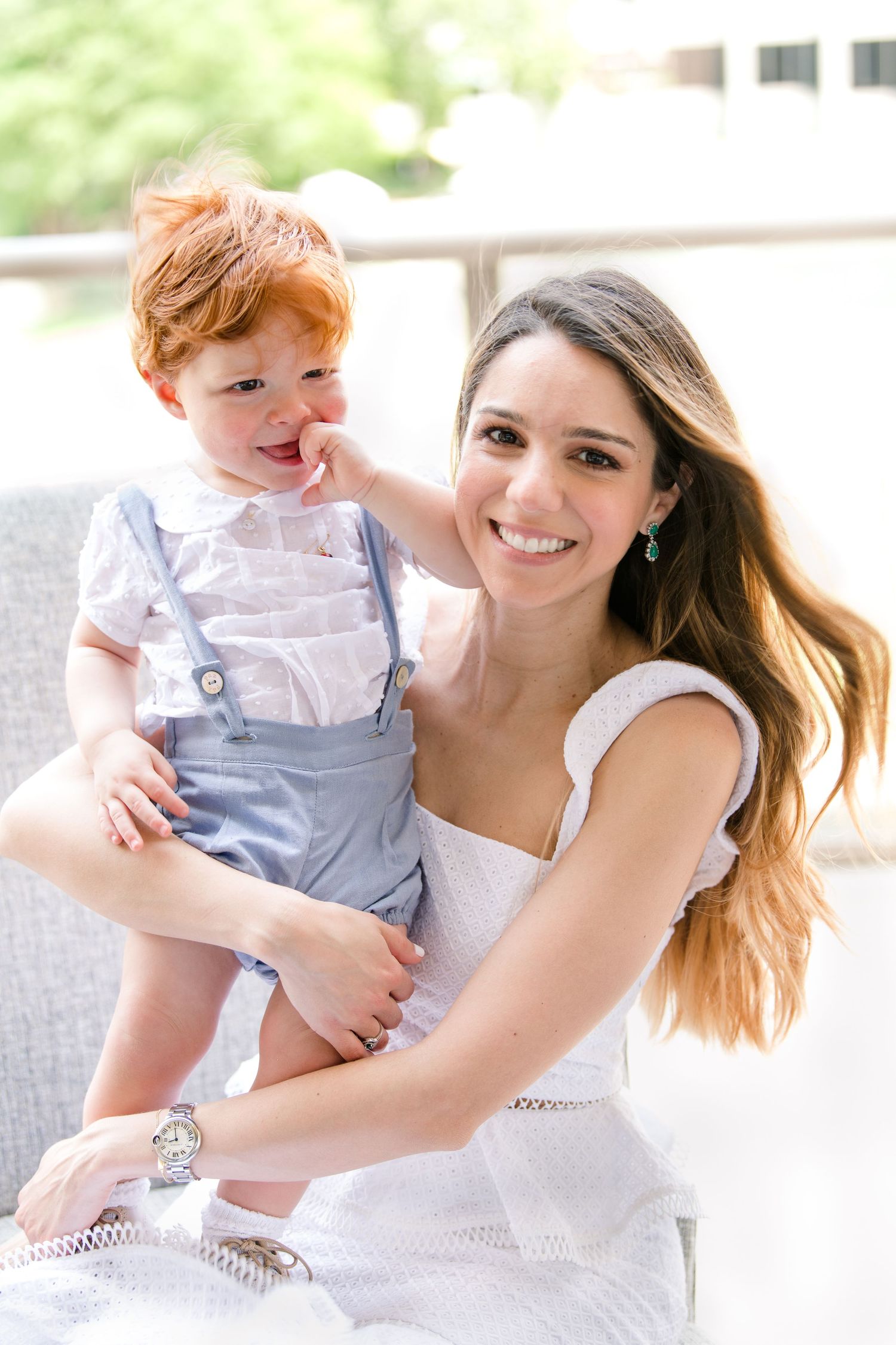 Mom and son sharing a joyful moment together on a cozy porch sofa.
