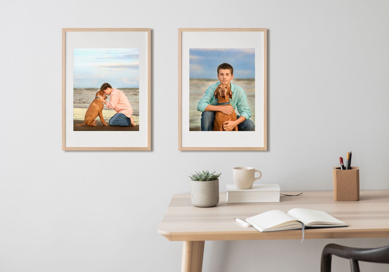 Two framed beachside portraits of teenagers displayed above a minimalist wooden desk with office supplies and decor.
