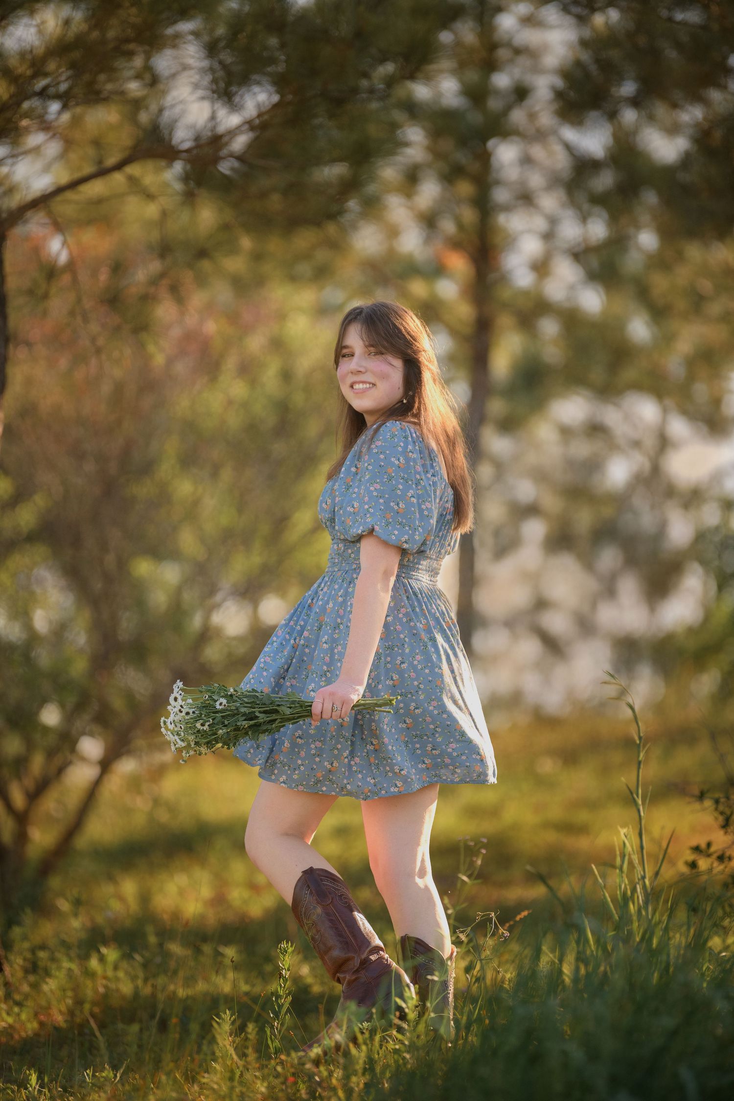A child in a blue floral dress runs playfully through a sunlit meadow during golden hour.