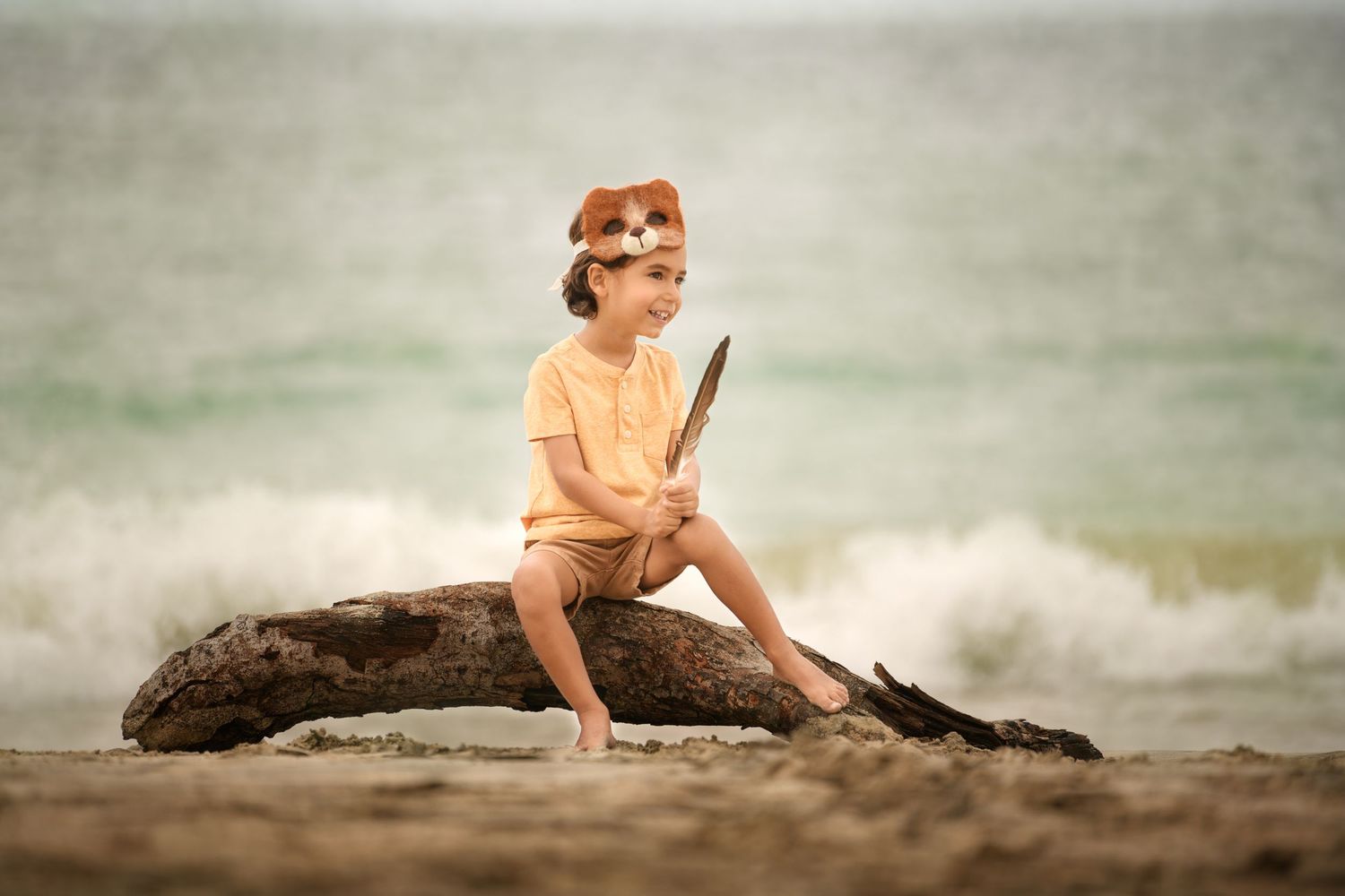 Child smiling near the ocean during a relaxed beach photo session in Houston.