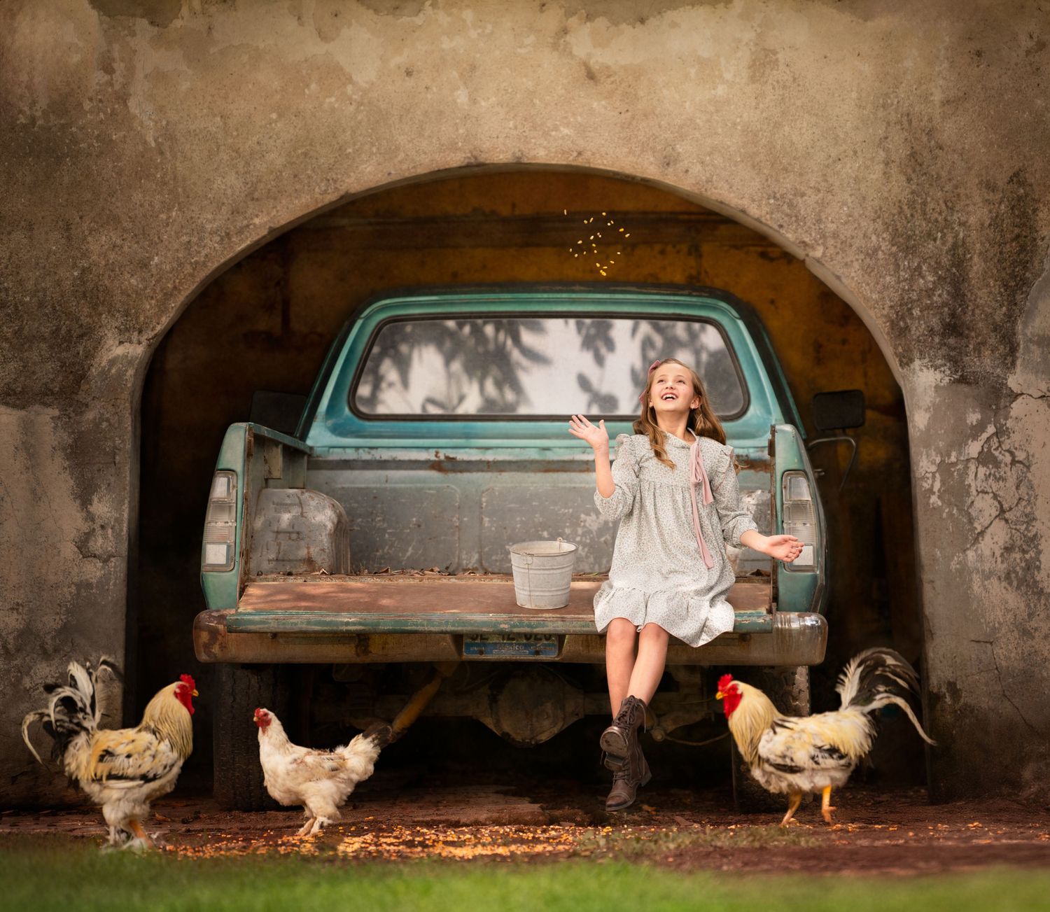 Rustic farm scene with chickens surrounding an old turquoise truck under an archway.