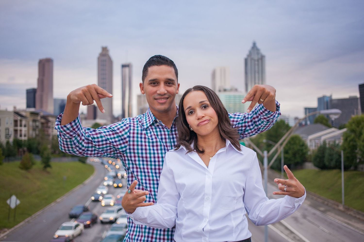 A family takes portraits with a city skyline in the background during golden hour.