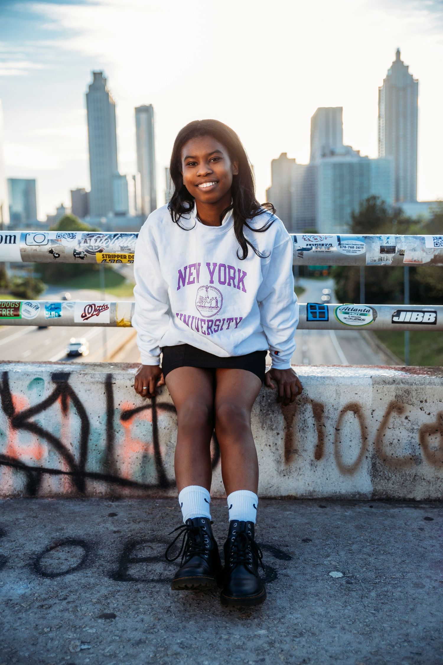 Casual portrait session against Atlanta cityscape with graffiti wall and highway views.